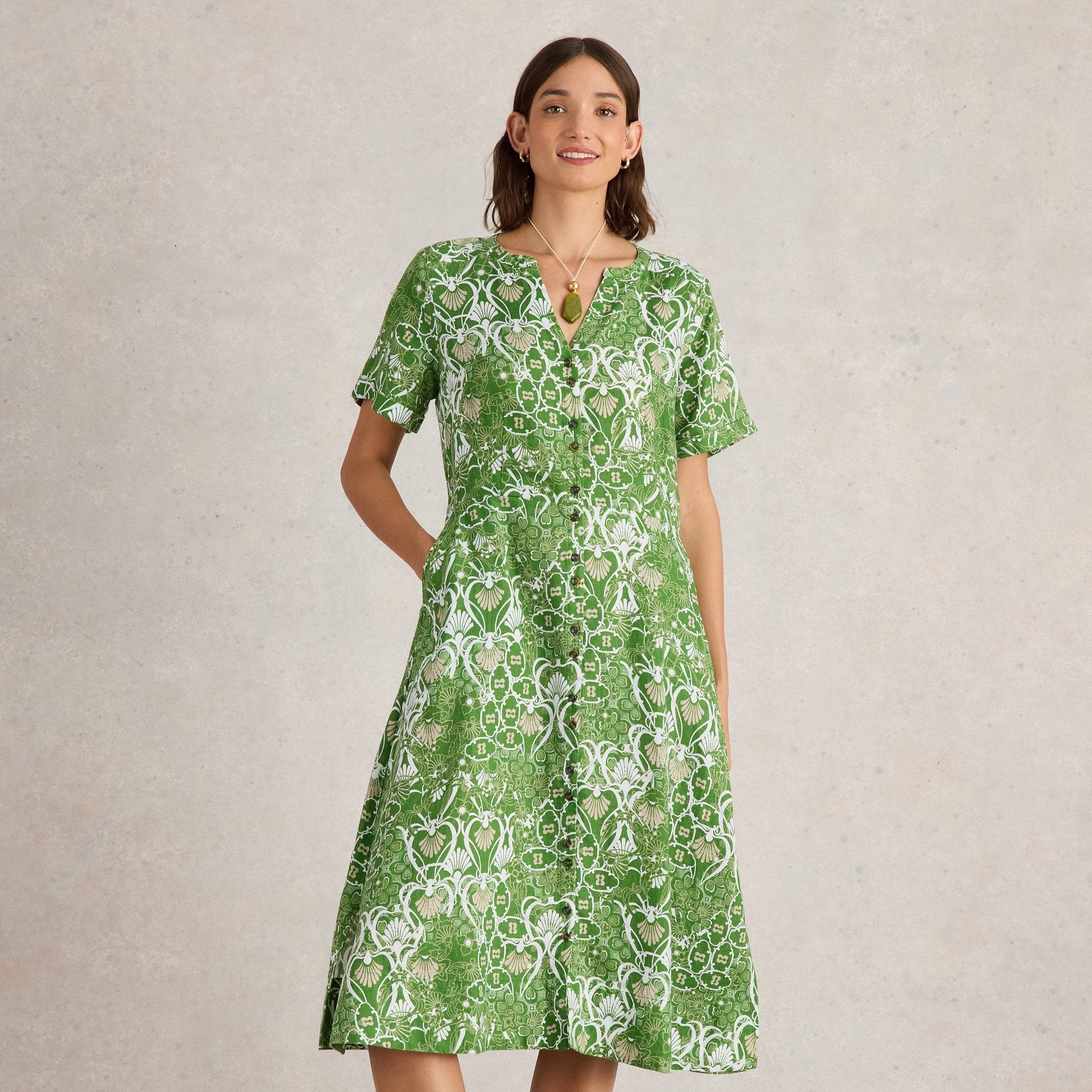 Green midi dress with short sleeves and a button-front closure.