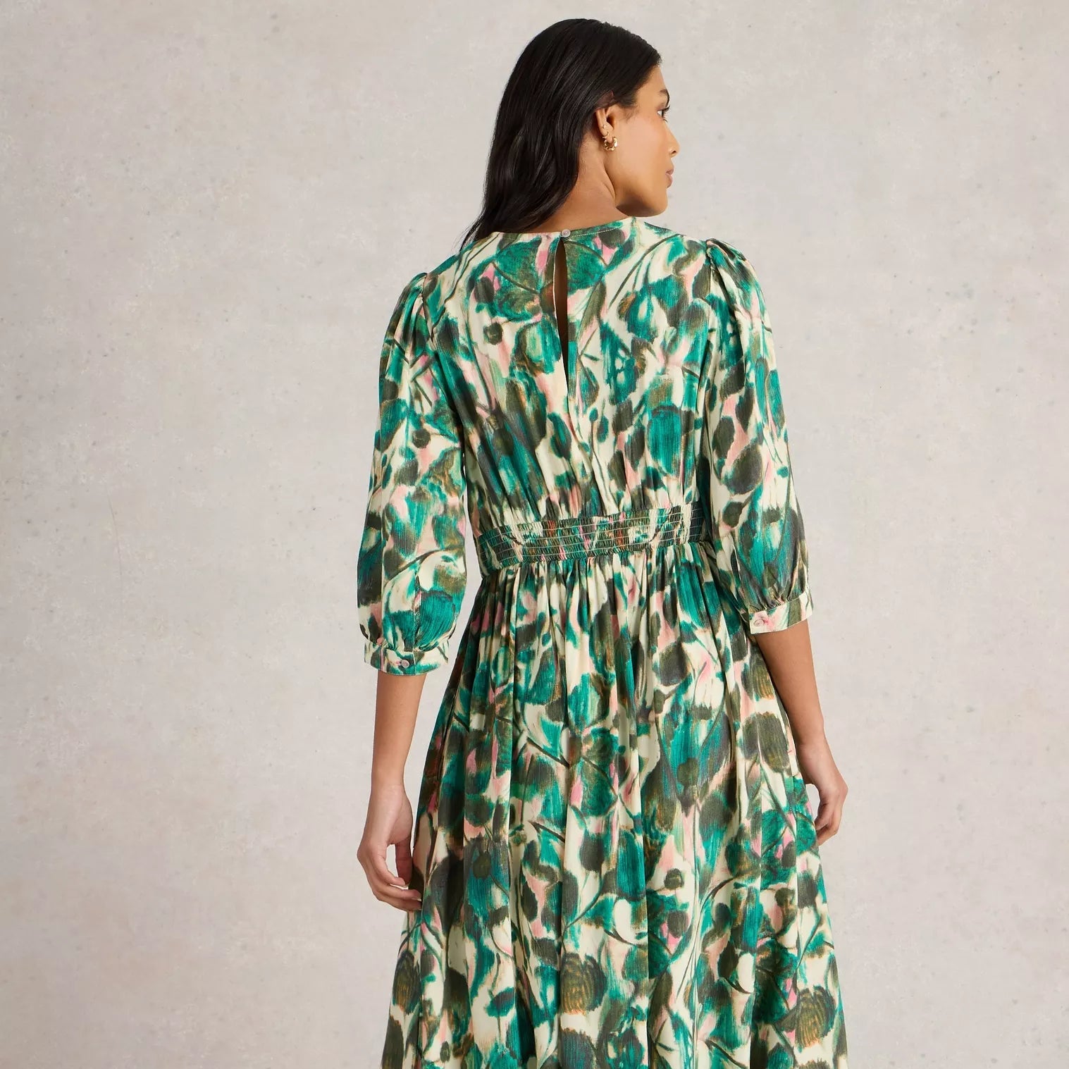 Green and cream midi dress with an abstract floral print, three-quarter sleeves, and a smocked waist.