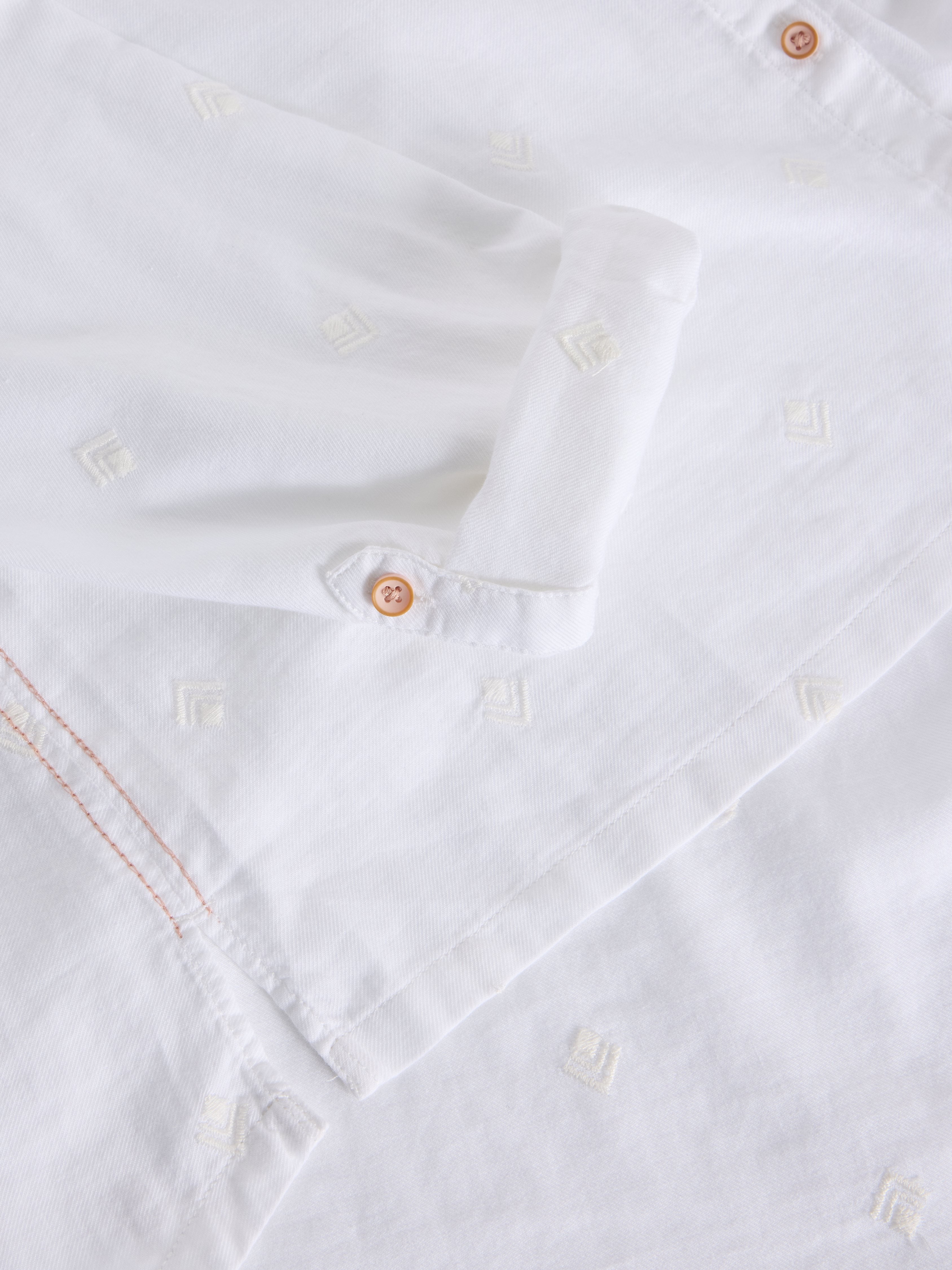 Close-up of a white shirt with buttons and stitching details