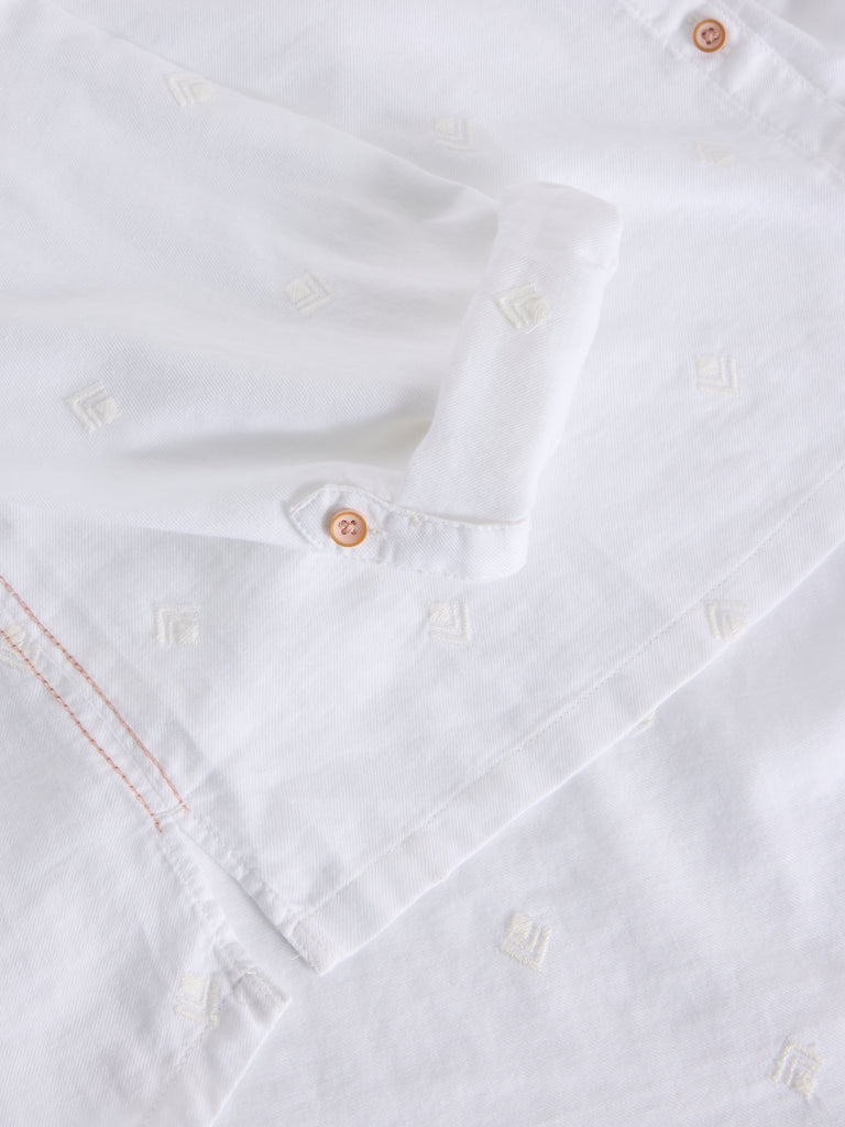 Close-up of a white shirt with buttons and stitching details
