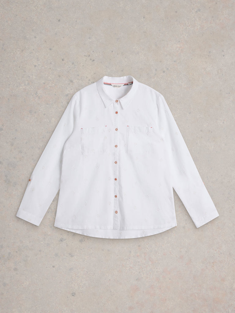White shirt with brown buttons on a beige background