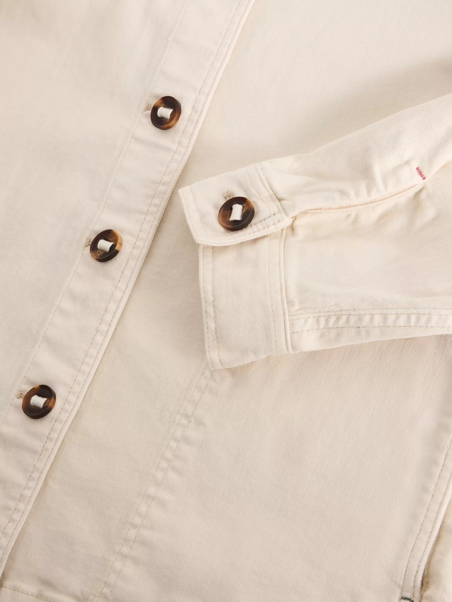 Close-up of a beige jacket with button details