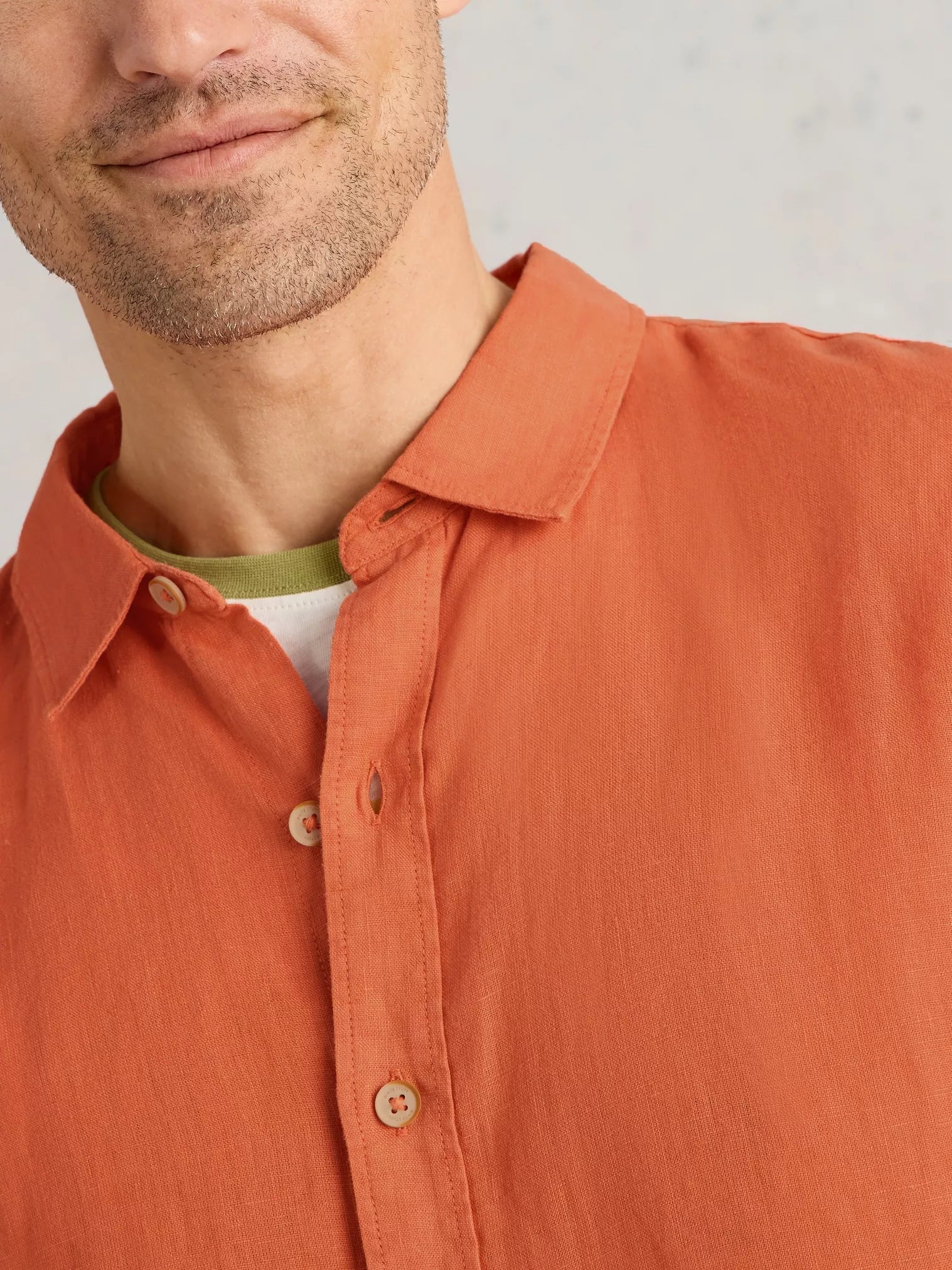 Burnt orange linen shirt with button-down collar and wooden buttons.