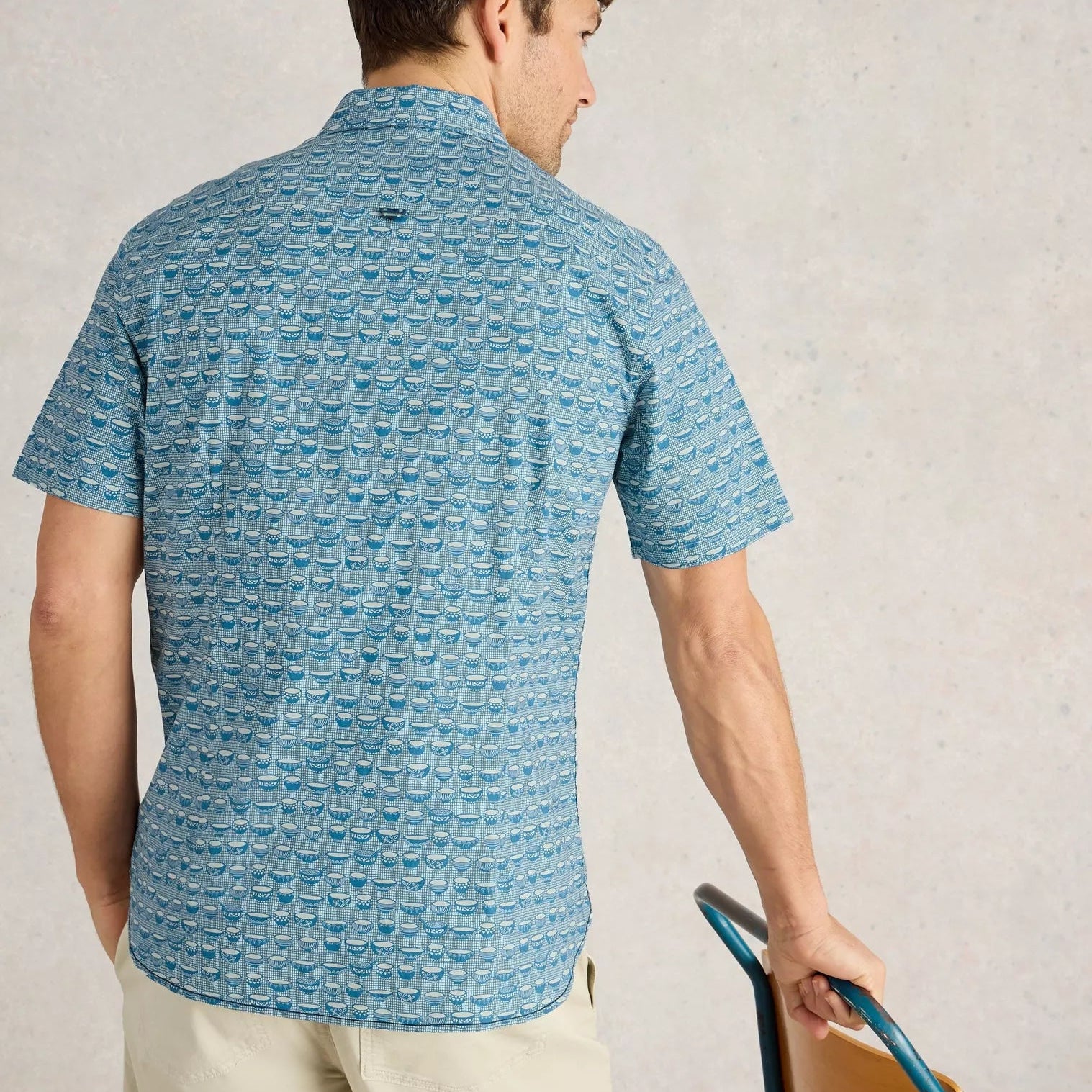 Men's short-sleeve button-down shirt in teal, featuring a repeating pattern of small, stylized bowls.