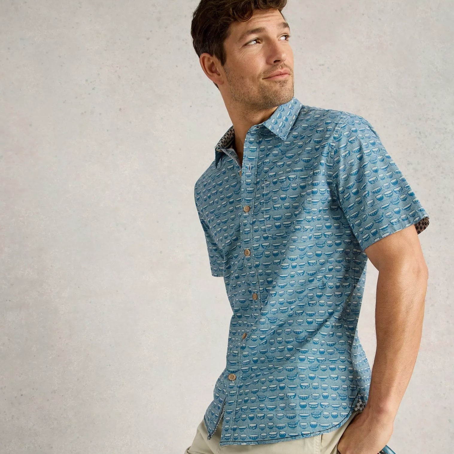 Men's short-sleeve button-down shirt in teal, featuring a repeating pattern of small, stylized bowls.