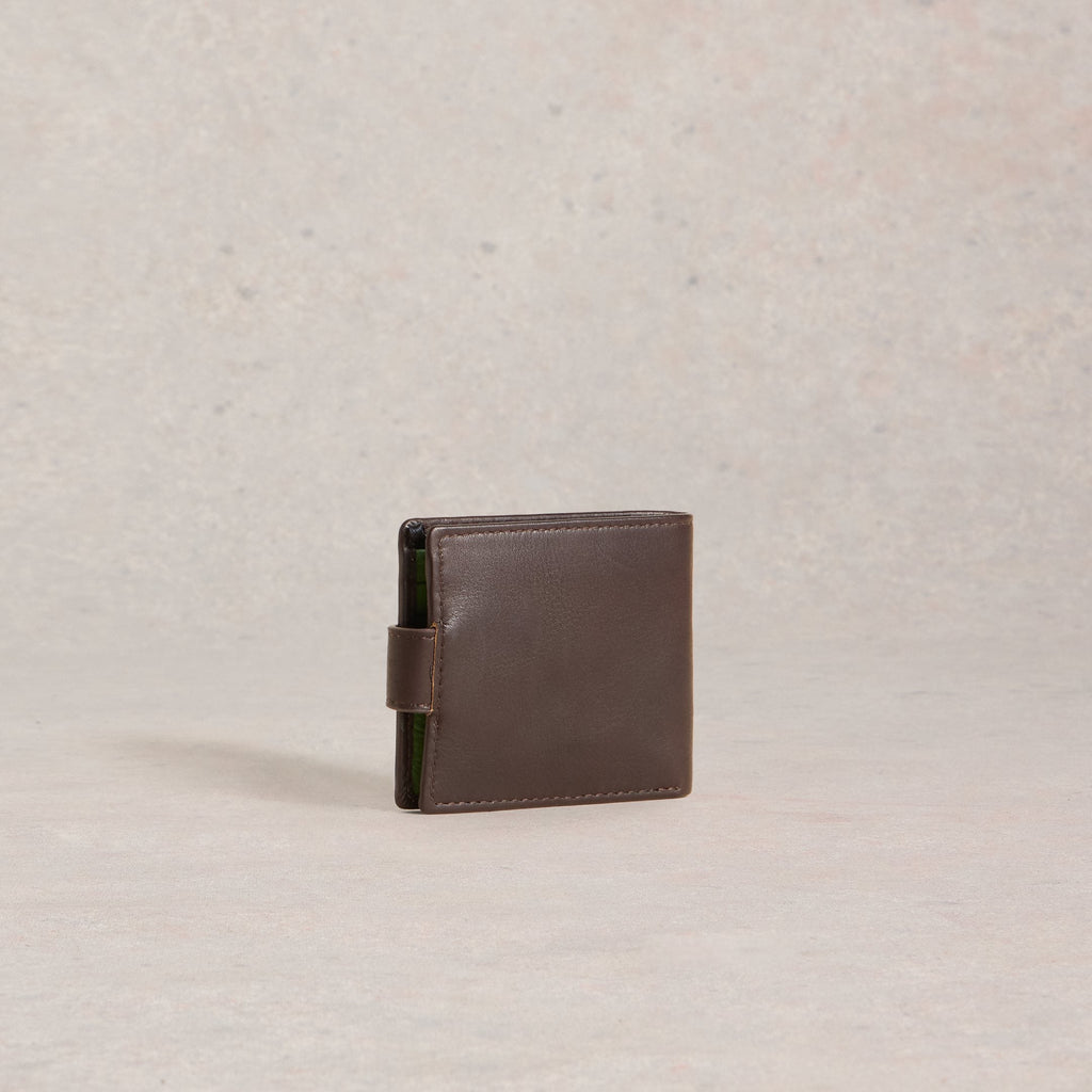 Brown leather wallet on a beige background
