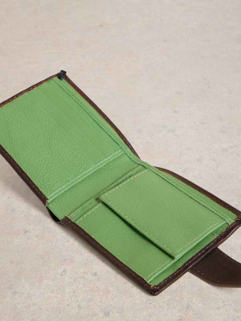 Green leather wallet on a textured beige surface