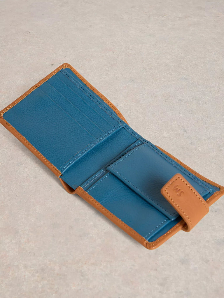 Tan leather wallet on a light beige textured background