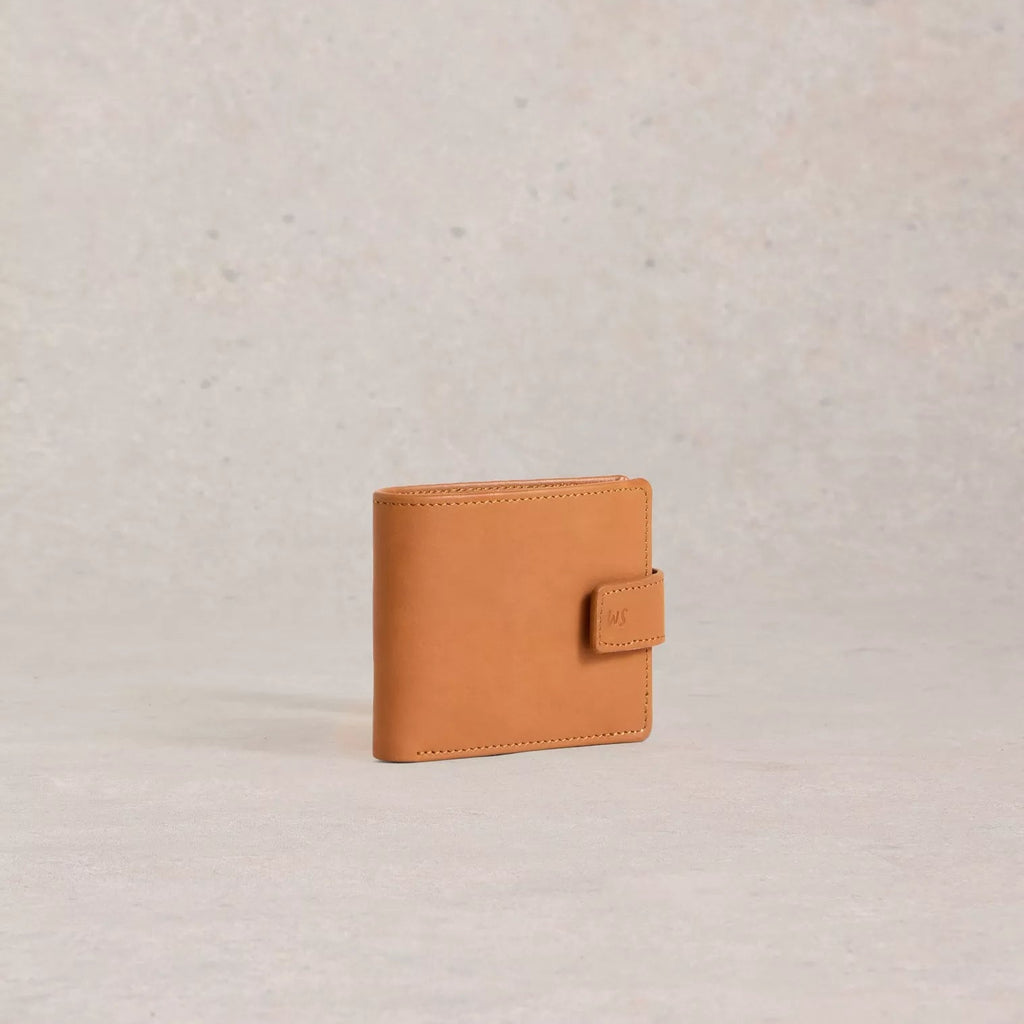 Tan leather wallet on a light beige background