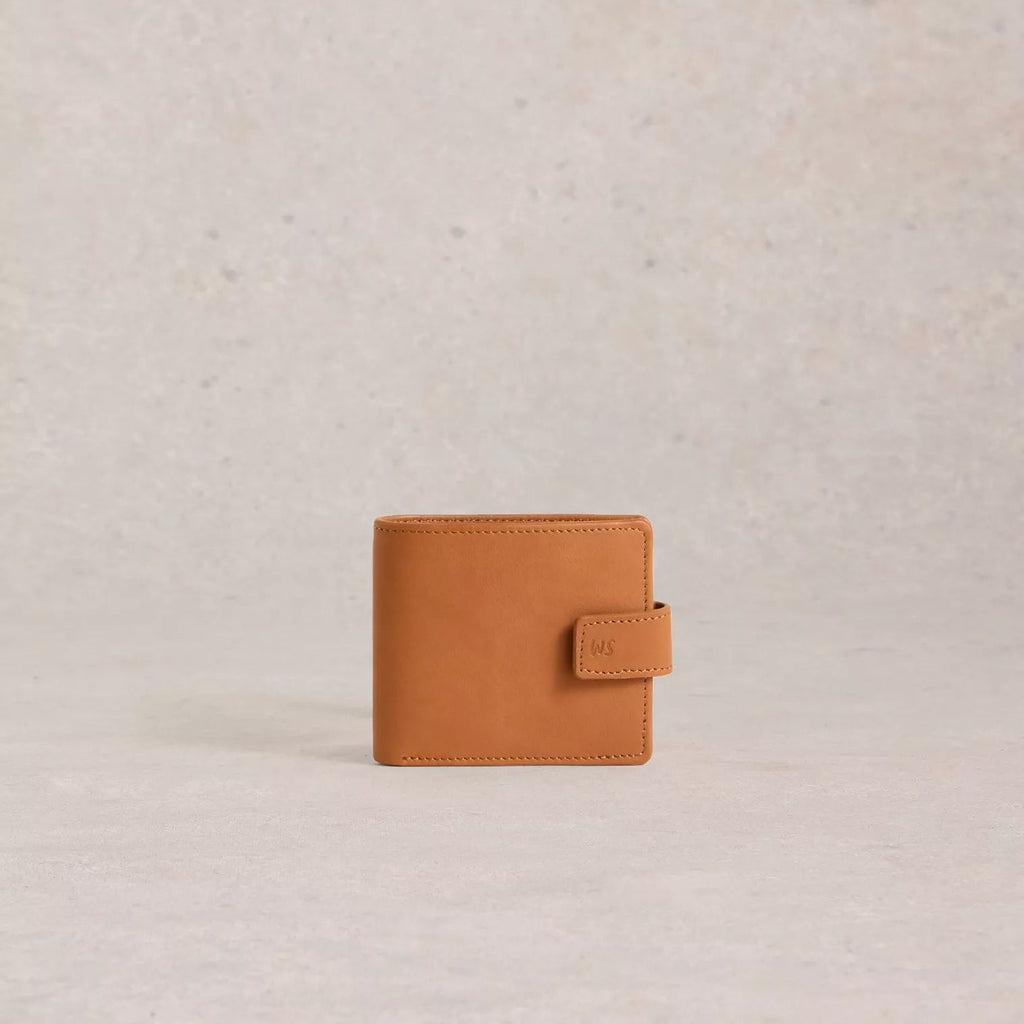 Tan leather wallet on a light beige textured background