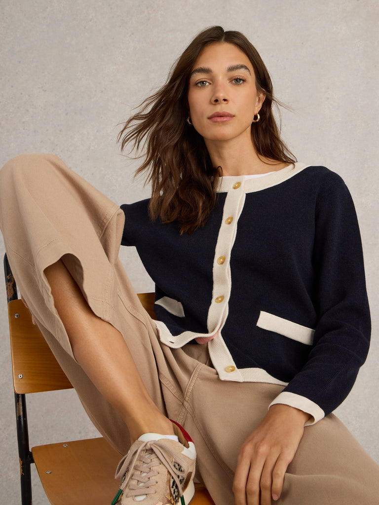 Navy blue and cream color block cardigan sweater with gold buttons and patch pockets.
