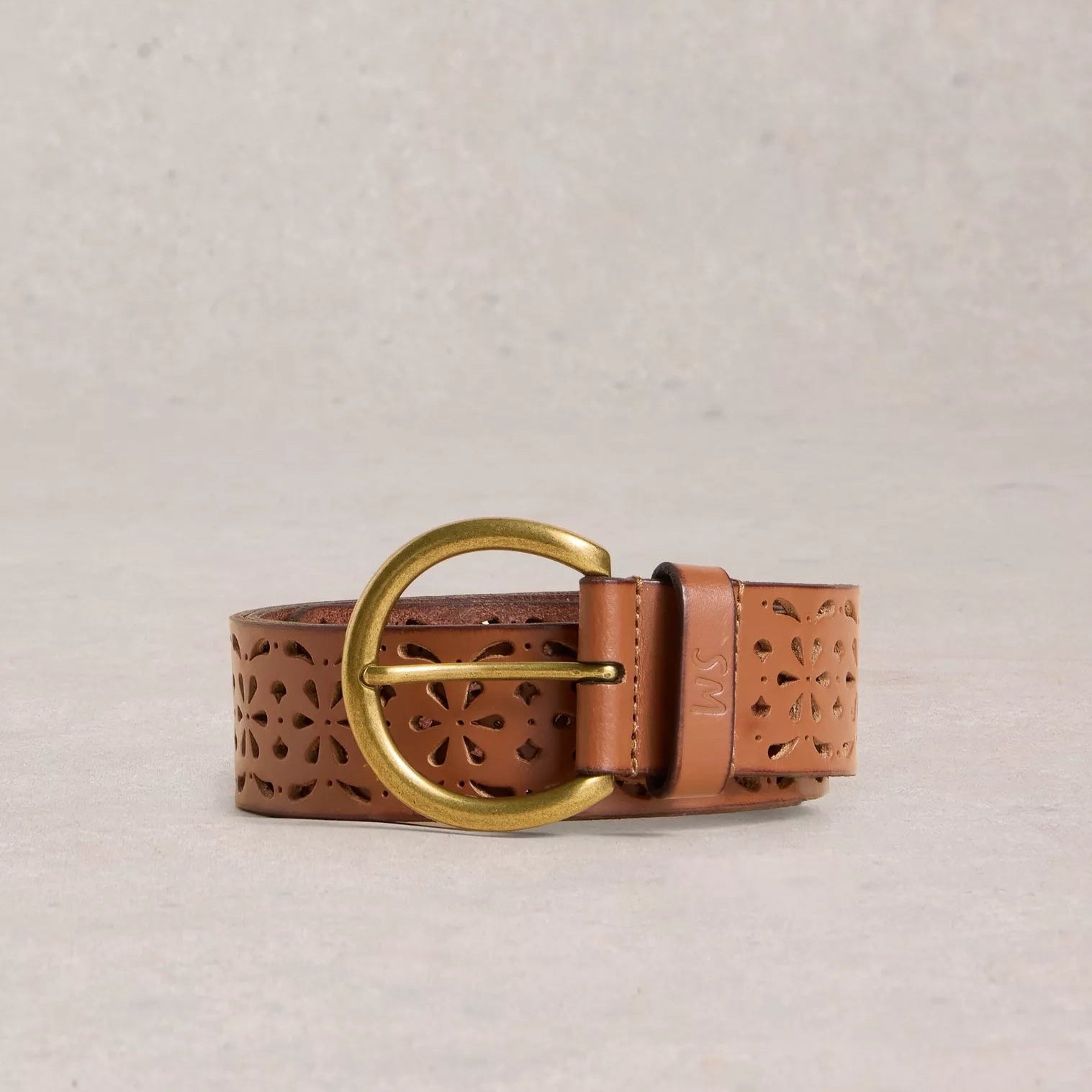 Brown leather belt with a gold buckle on a beige background