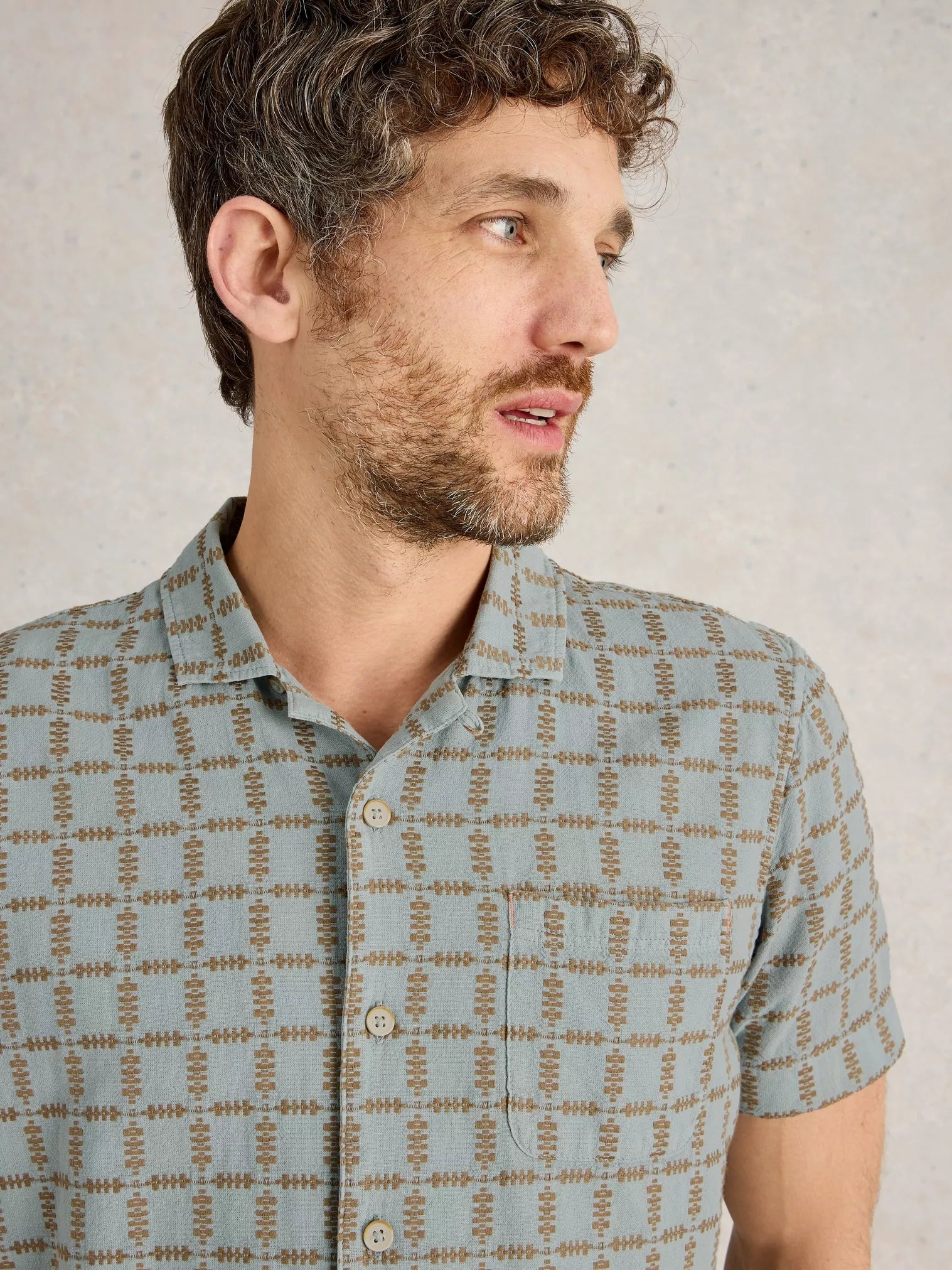 Men's short-sleeve shirt in light blue with a brown geometric grid pattern.