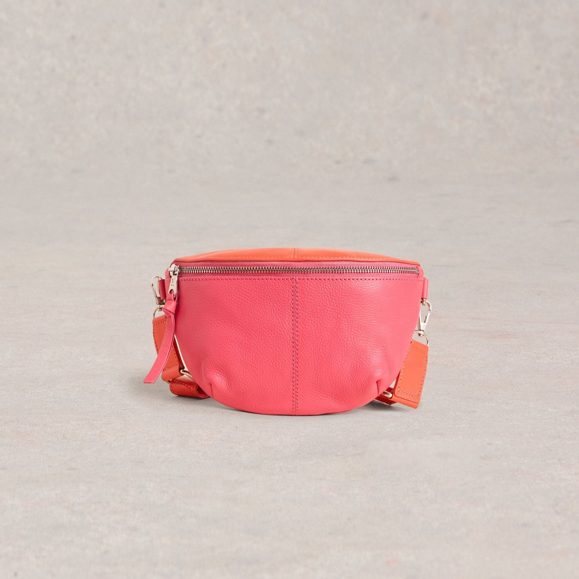 Pink leather fanny pack with a silver zipper and coral-colored straps.