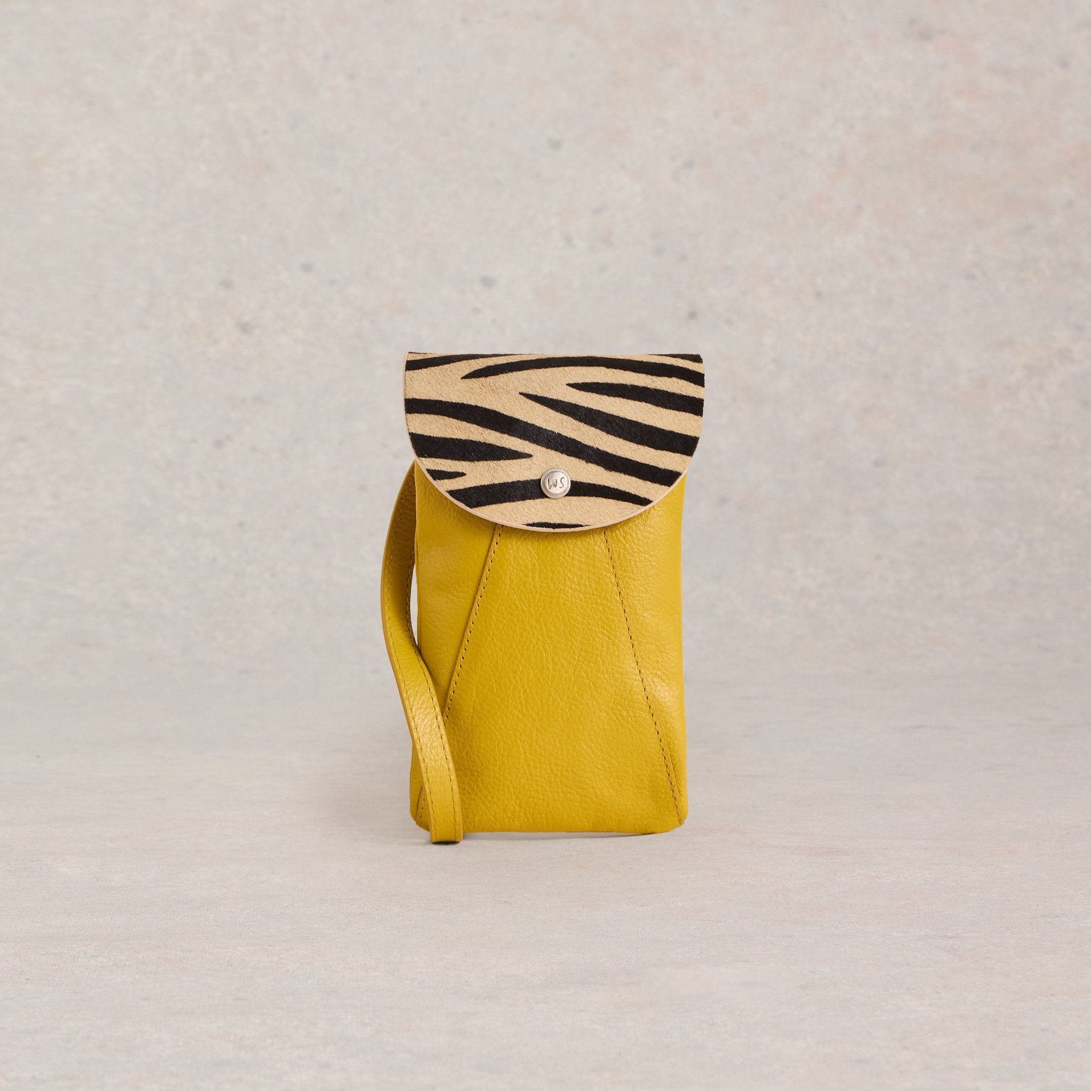 Mustard yellow leather crossbody phone bag with a zebra-striped flap closure.