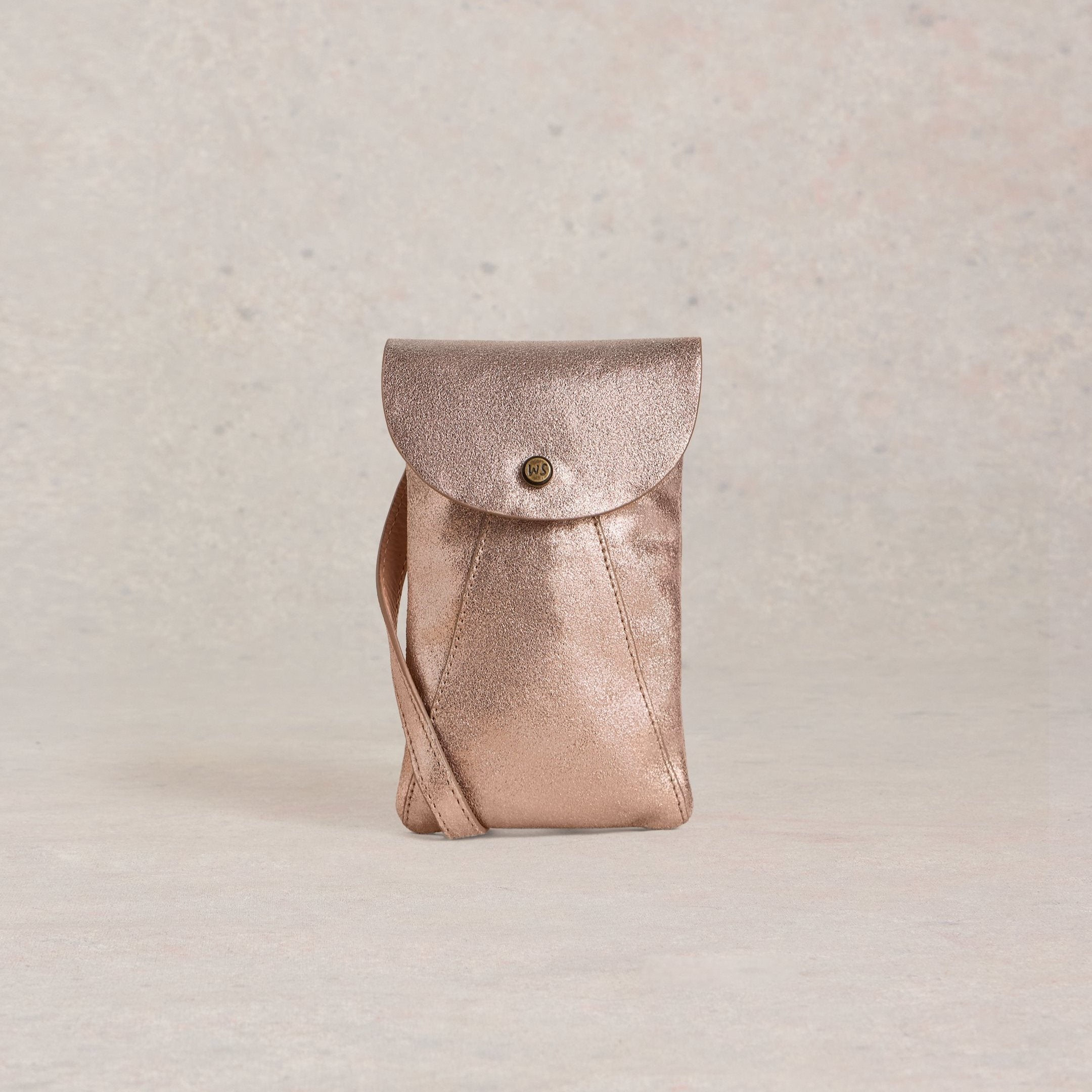 Rose gold metallic leather crossbody bag with a flap closure and adjustable strap.
