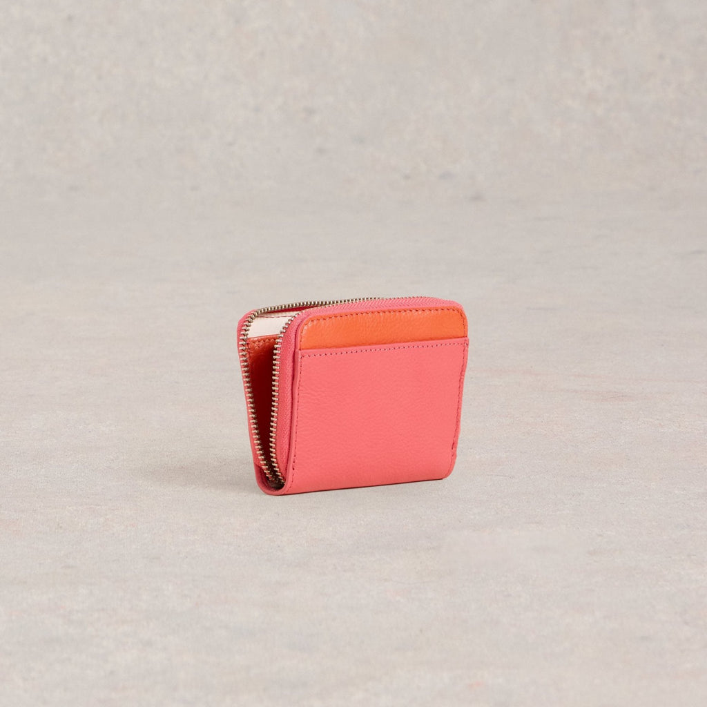 Coral pink leather zip-around wallet with a contrasting orange interior detail.