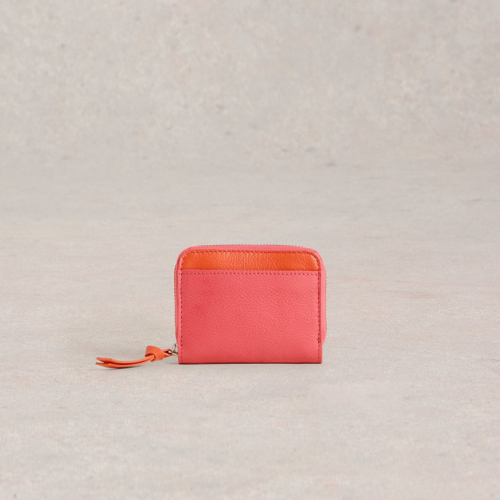 Coral leather zip-around wallet with an orange interior.