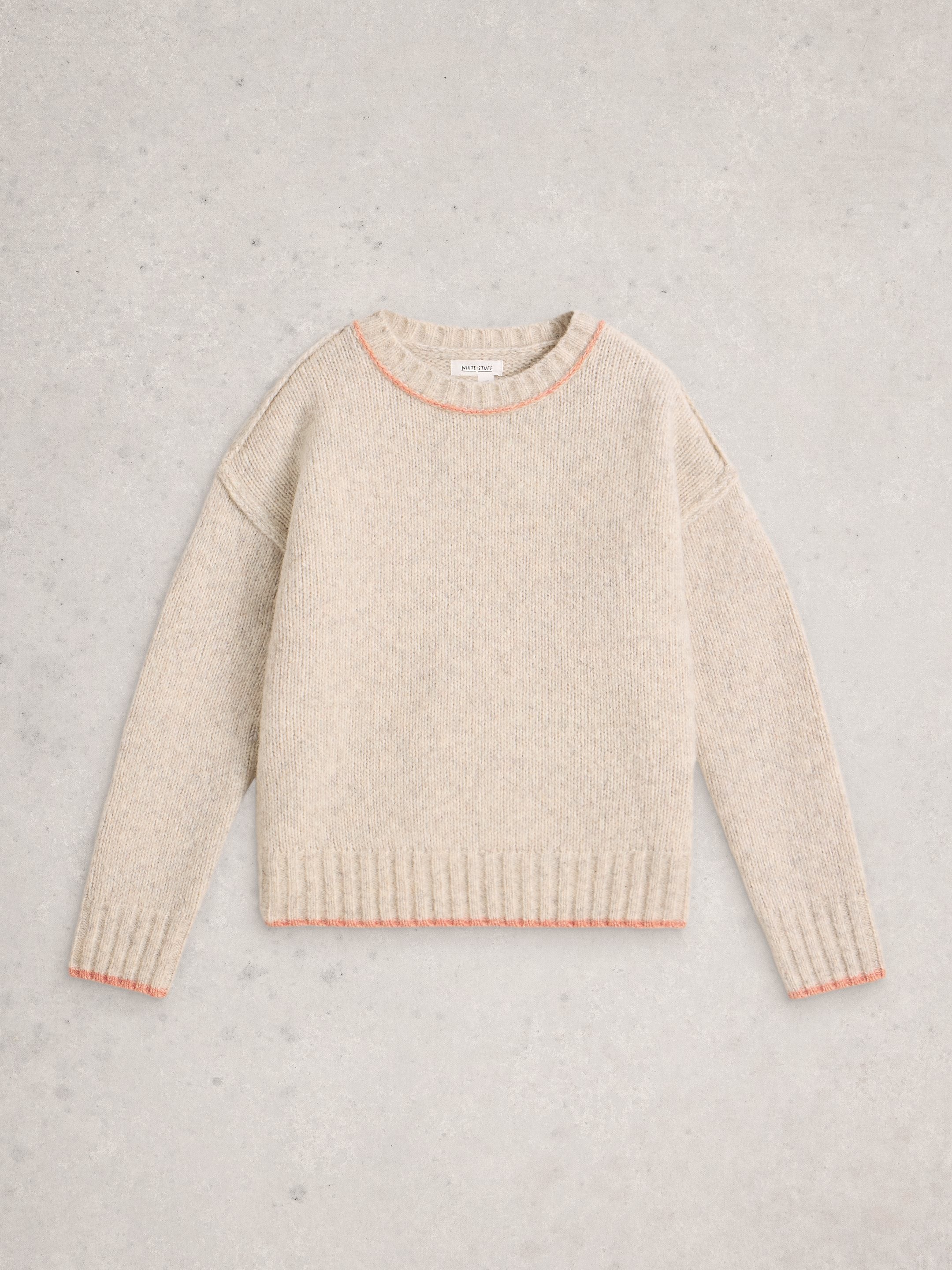 Beige sweater with pink trim on a light gray background