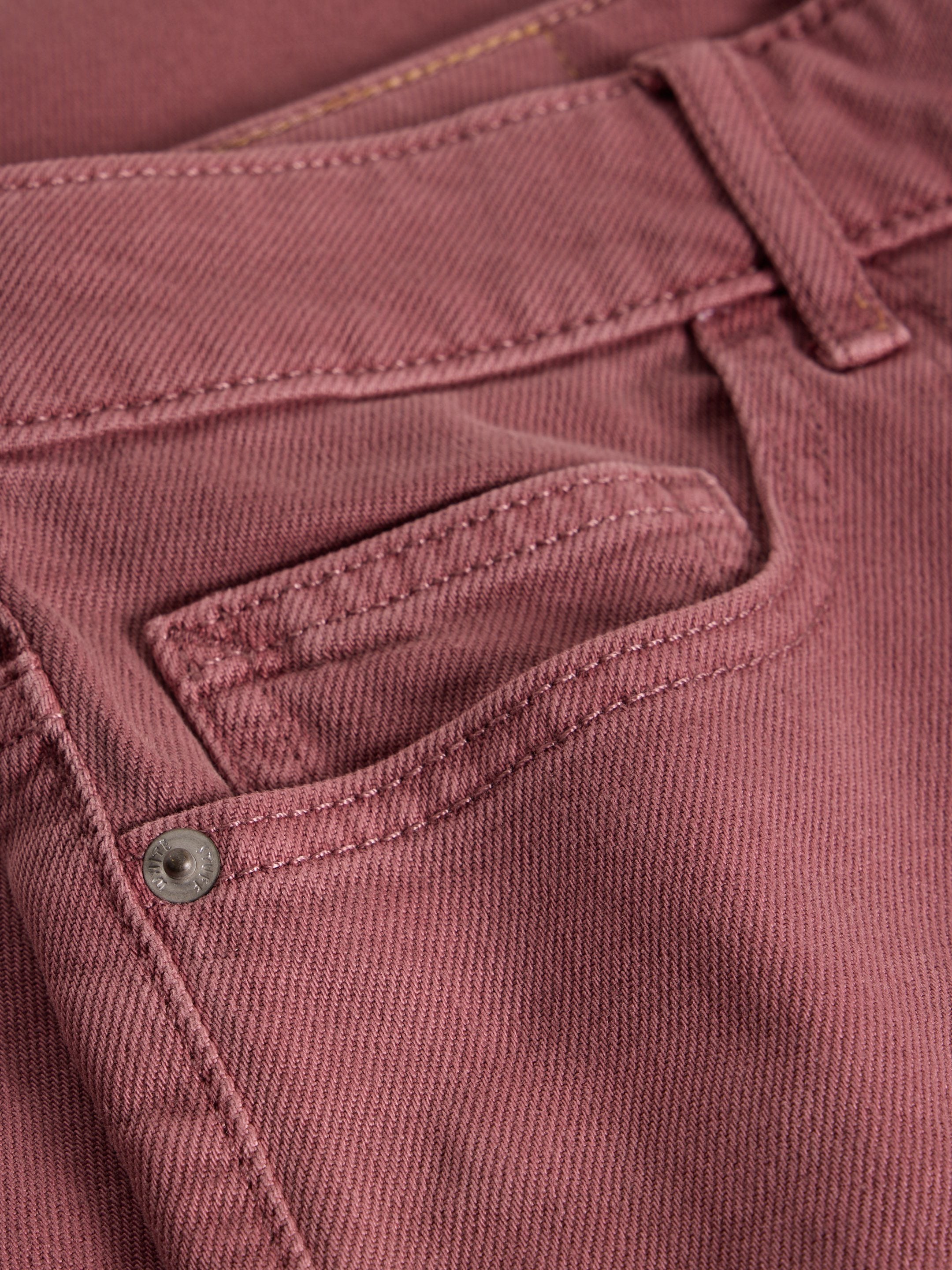 Close-up of a maroon pants pocket with stitching details.