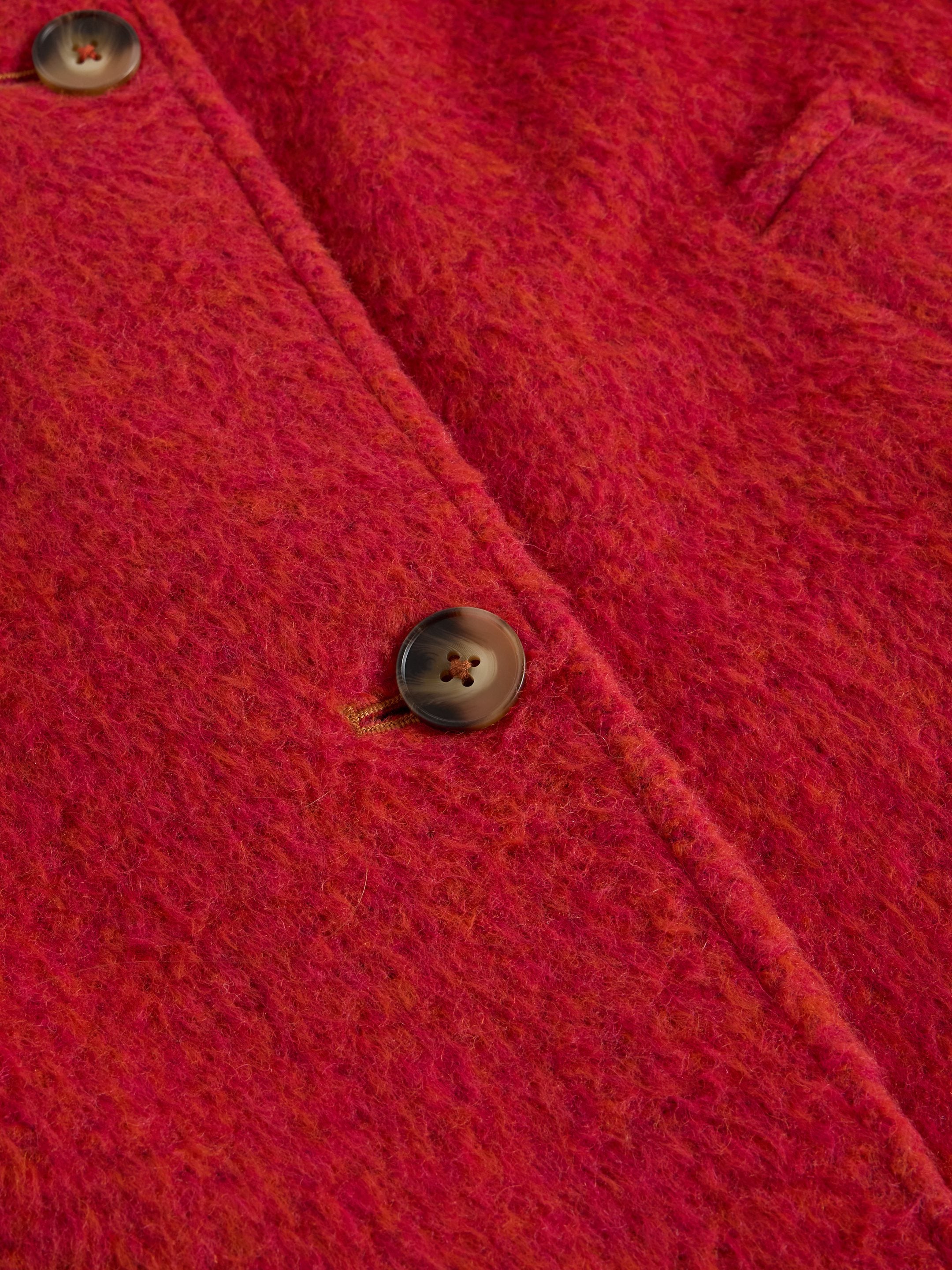 Close-up of a red textured fabric with buttons