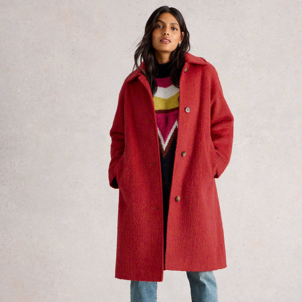 Person wearing a red coat with a neutral background