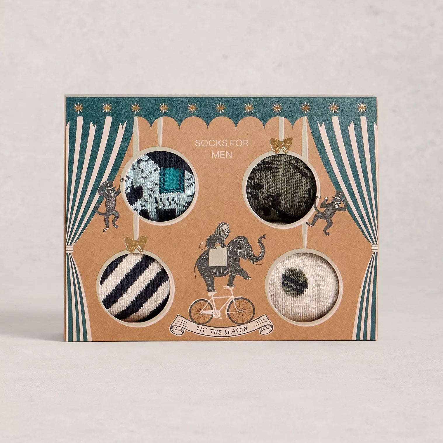 Set of men's socks in a decorative box with striped curtains on a light gray background