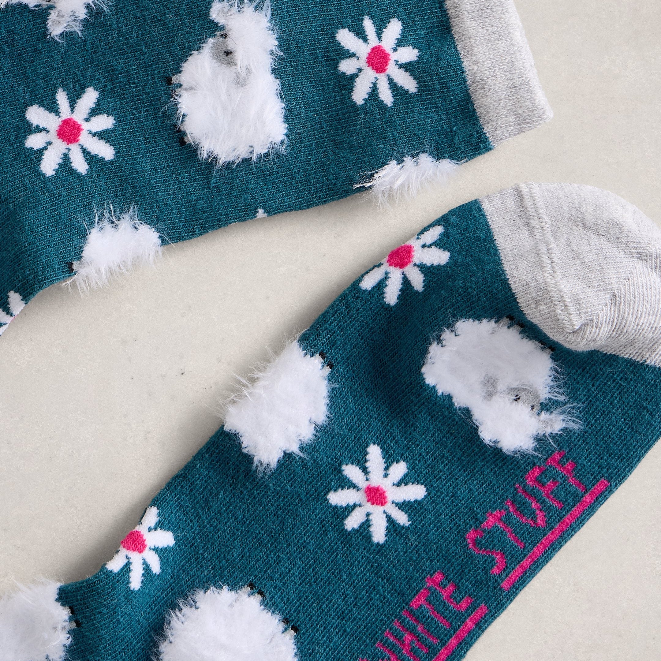 Teal sock with white hedgehogs and flowers, featuring 'White Stuff' branding.