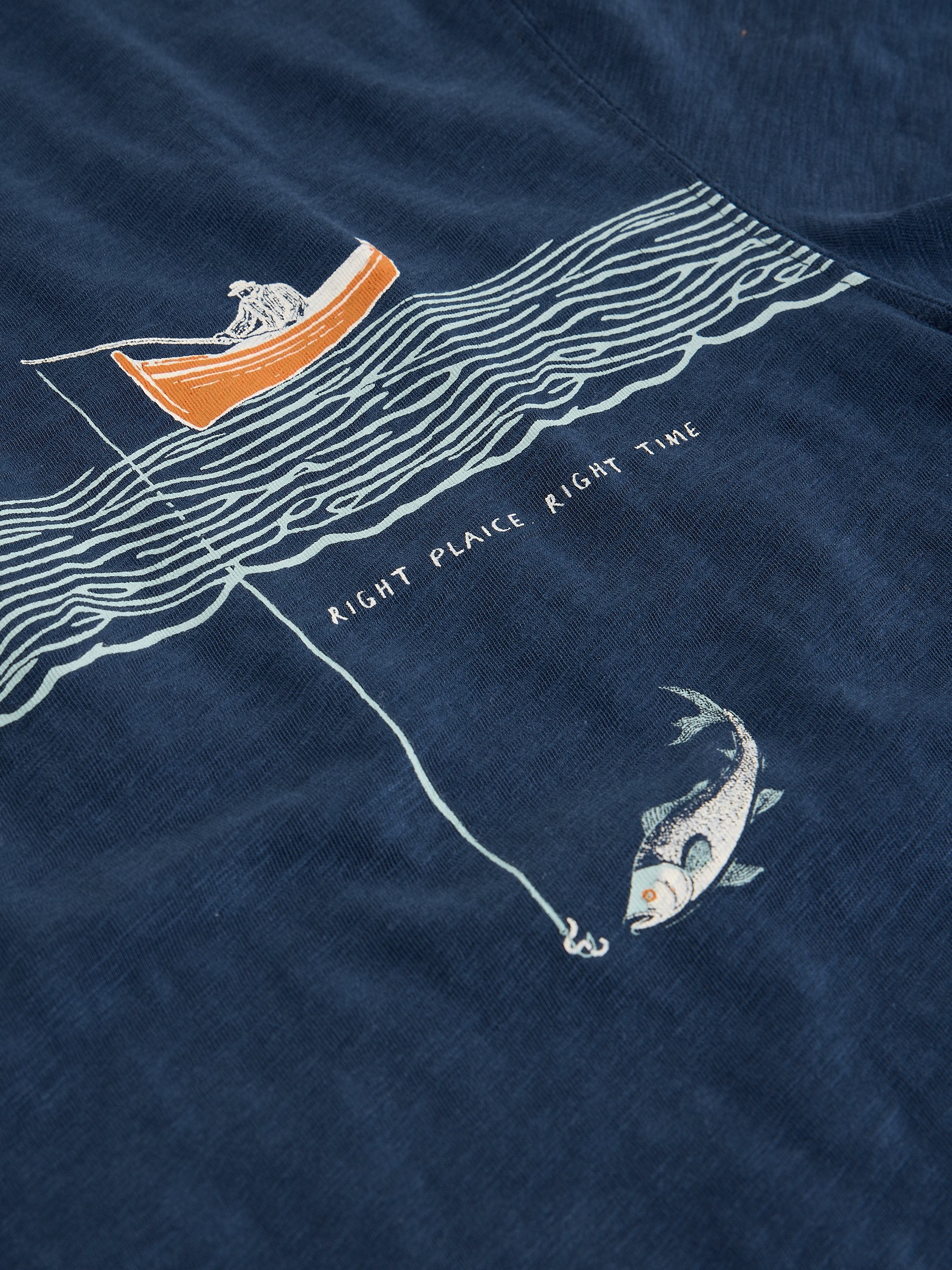 Navy blue shirt with a boat, fish, and wavy lines design on a dark background