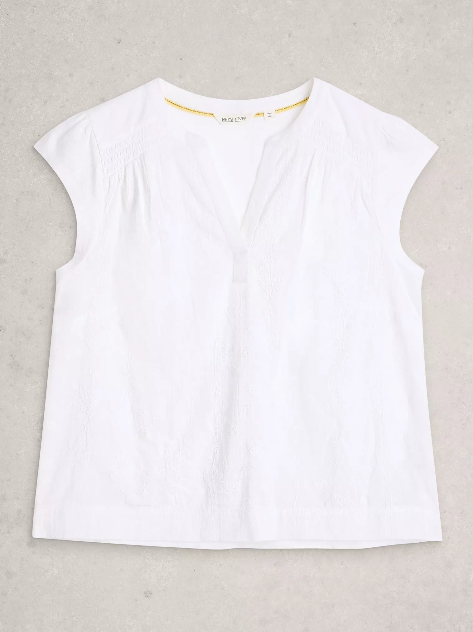 White sleeveless top on a light gray background