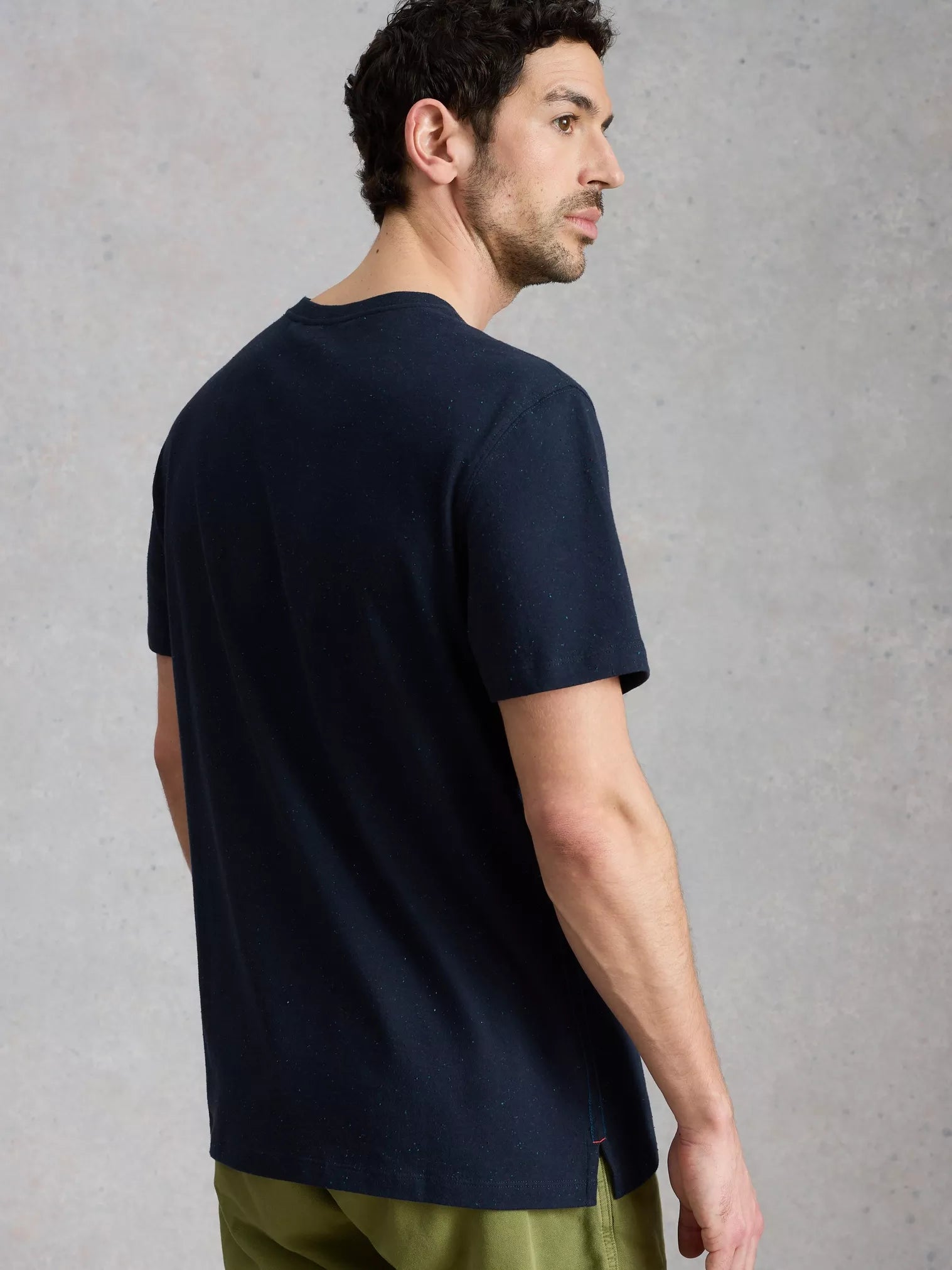 Man wearing a navy blue t-shirt against a gray background