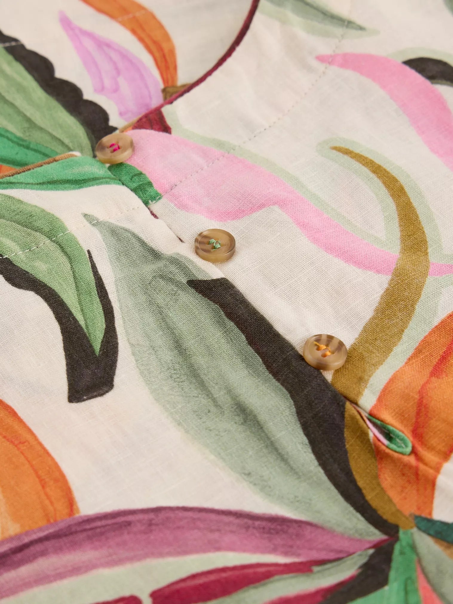 Close-up of a fabric with colorful abstract patterns and buttons.