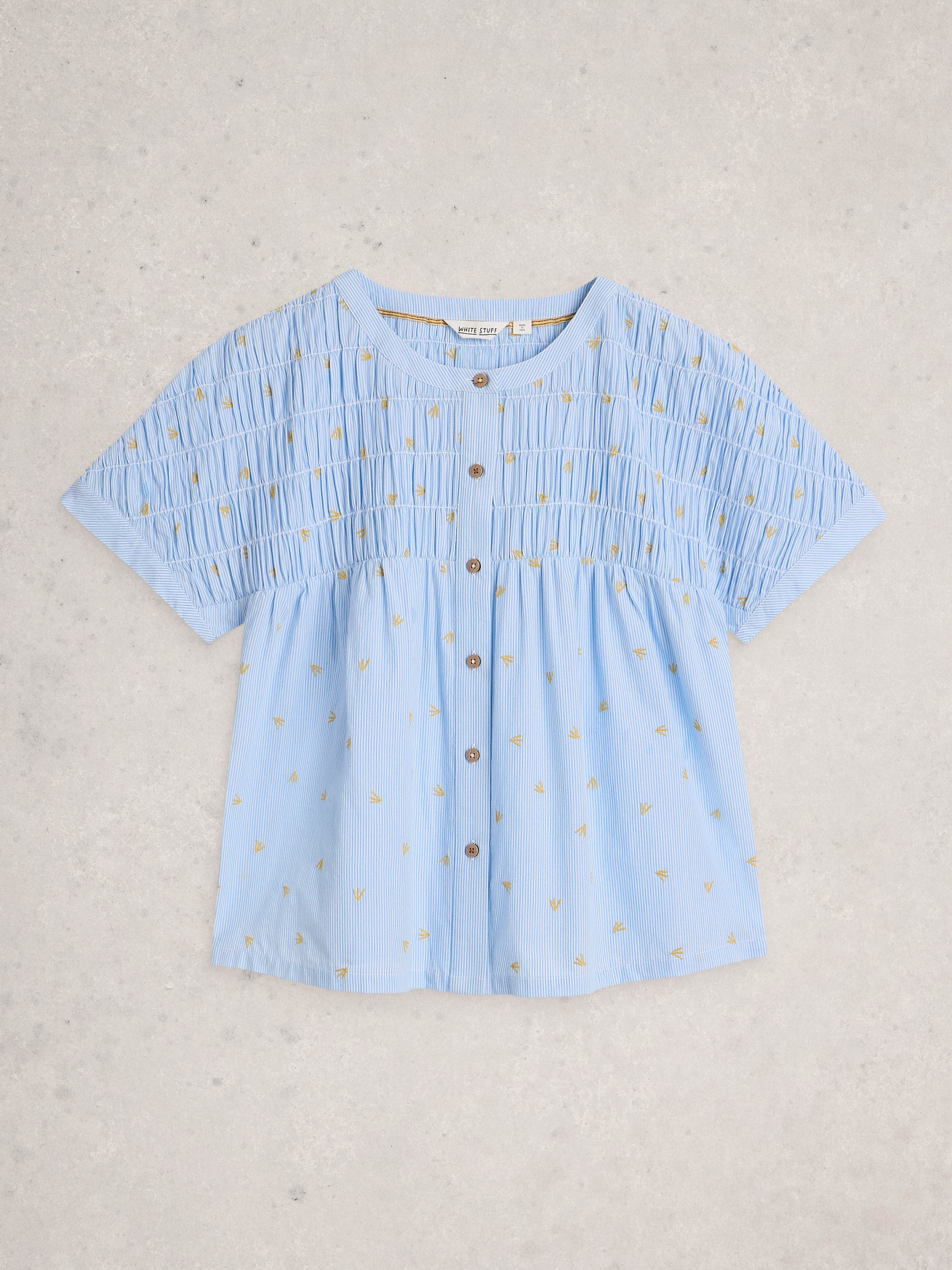 Light blue blouse with small patterns on a light gray background