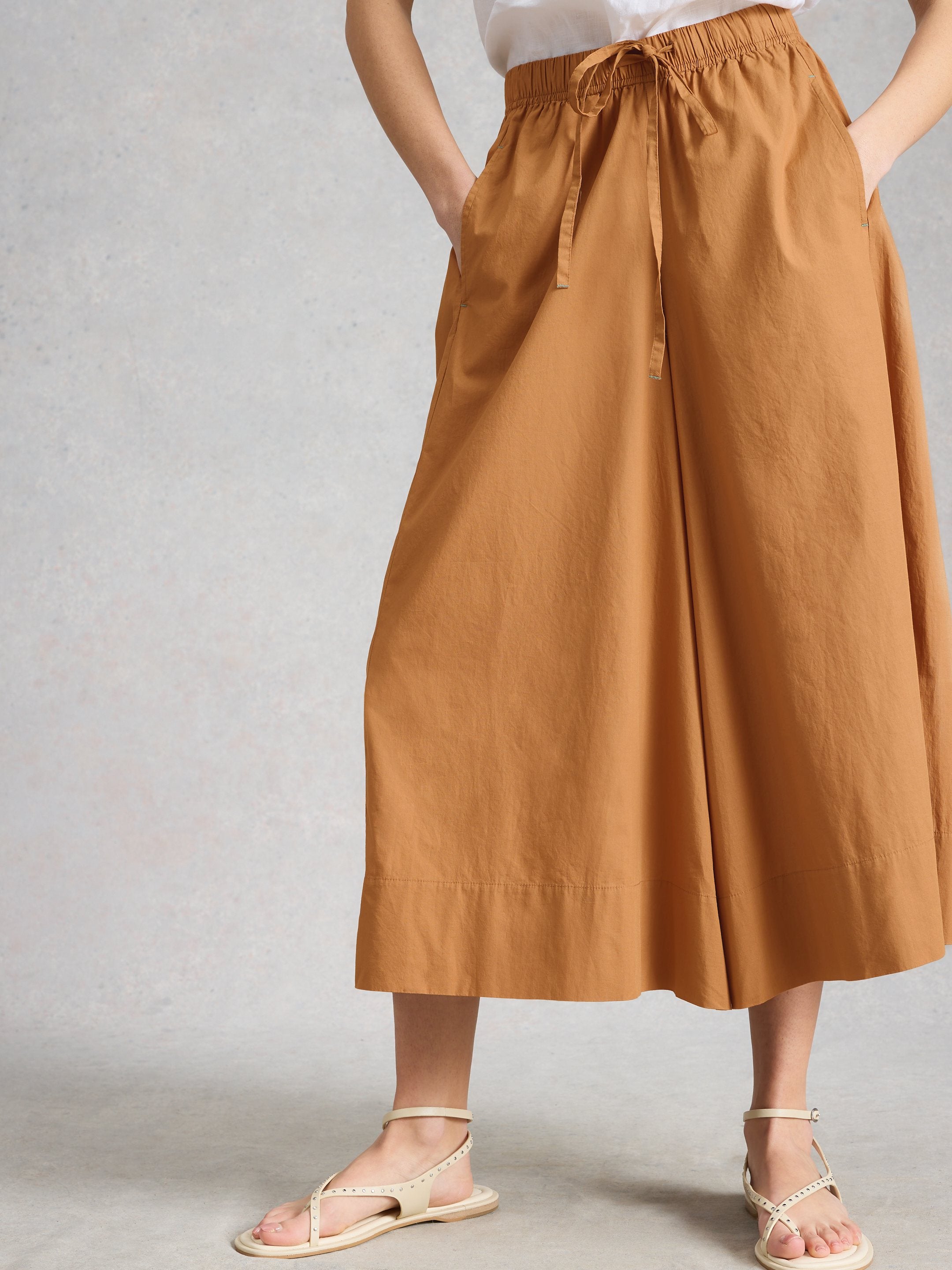 Brown wide-leg pants worn by a person on a plain background