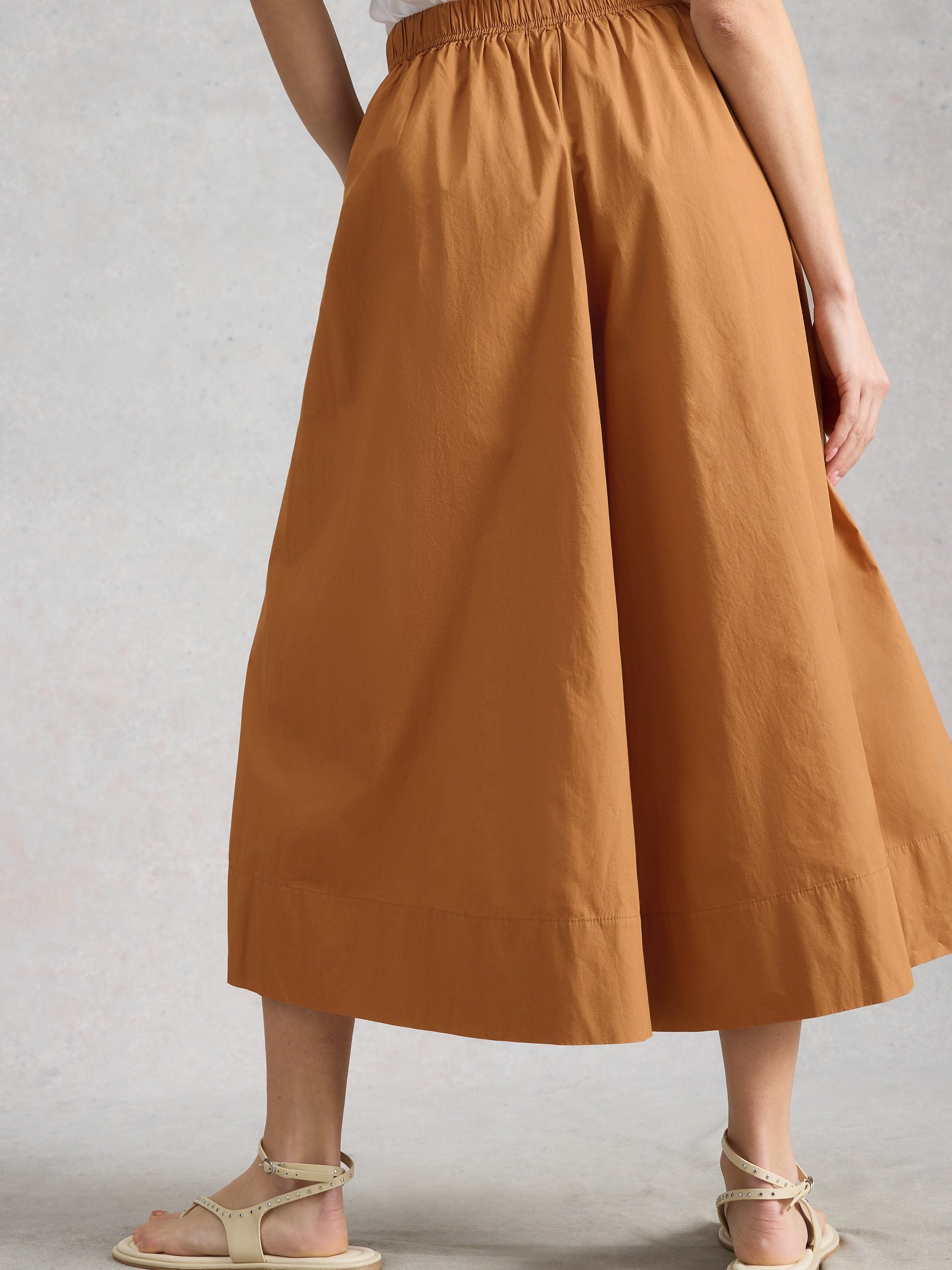 Brown skirt worn by a person on a plain background