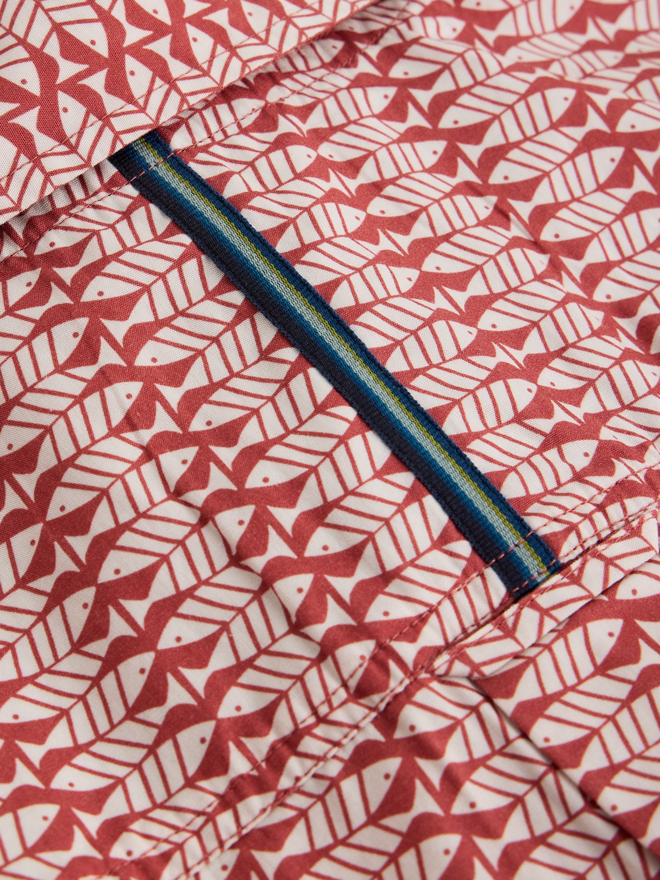 Close-up of a fabric with red and white pattern and a blue zipper.