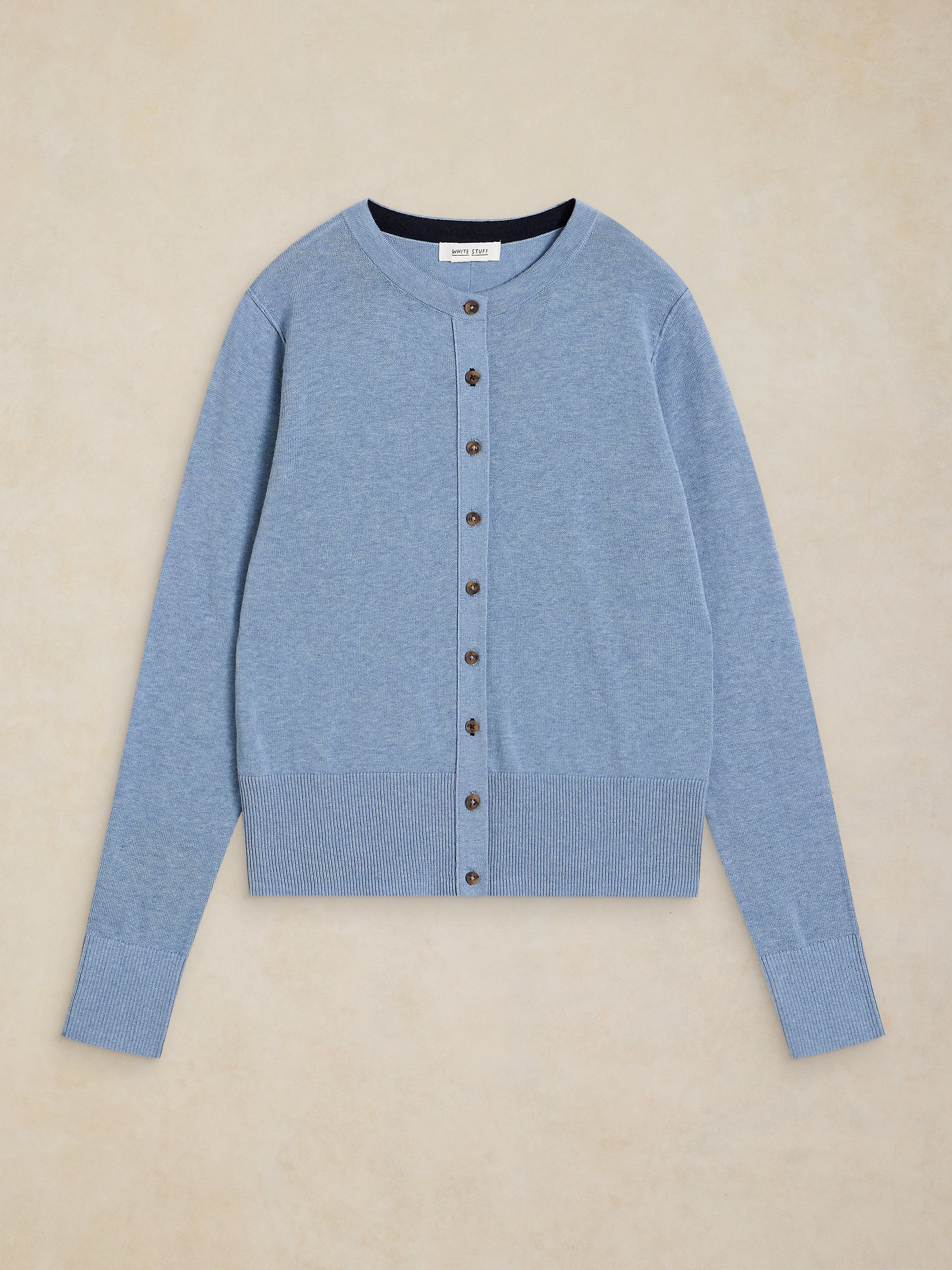 Blue cardigan with buttons on a beige background