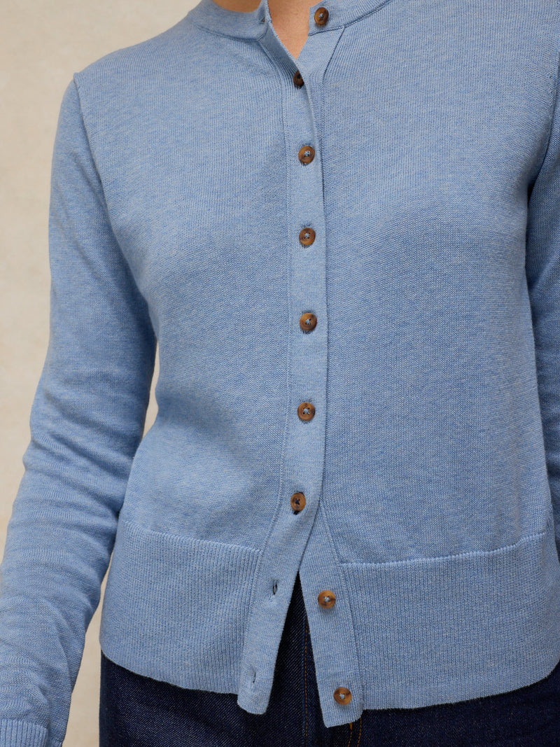 Light blue cardigan with brown buttons on a neutral background
