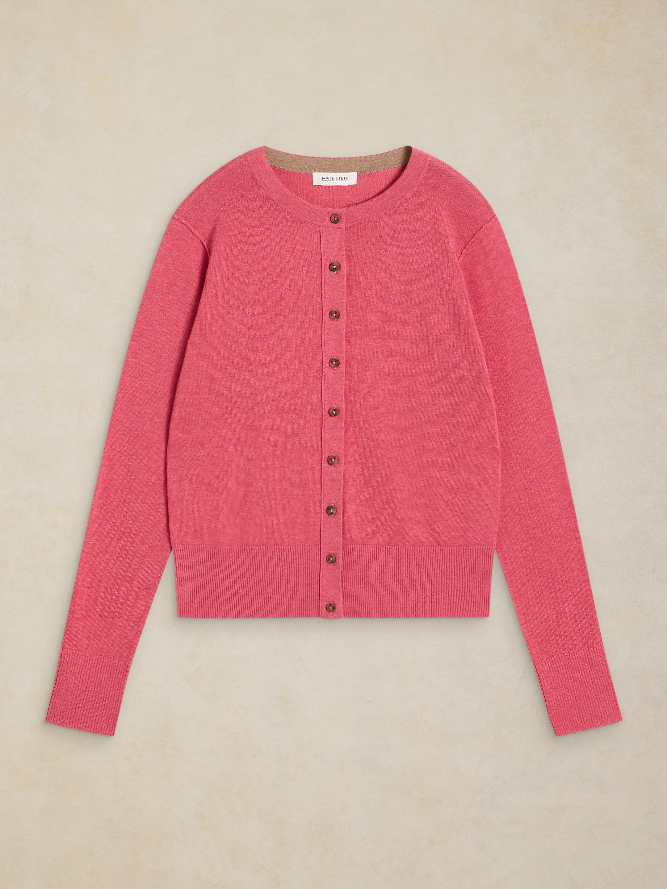Pink cardigan with buttons on a beige background