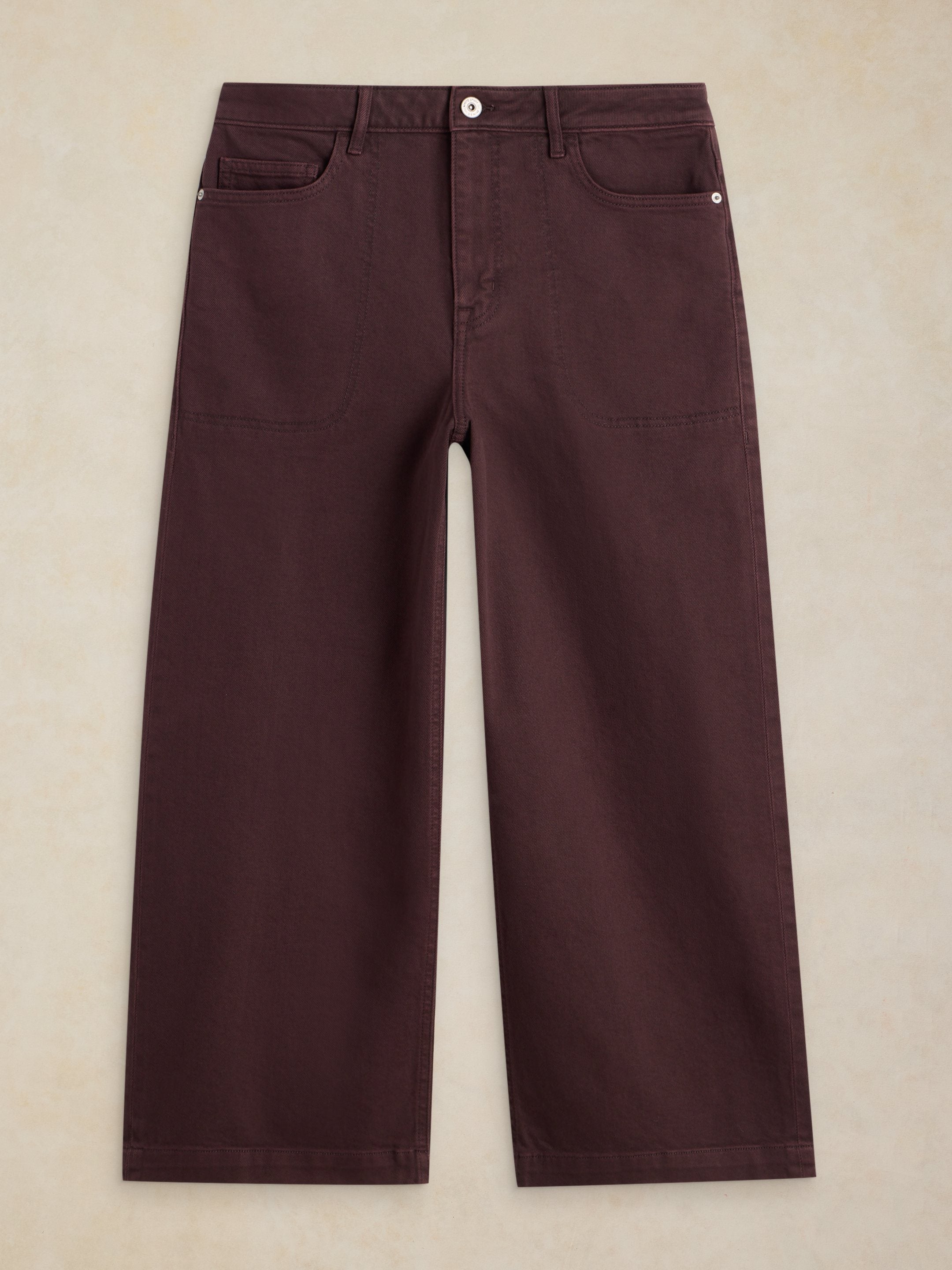 Pair of maroon pants on a beige background