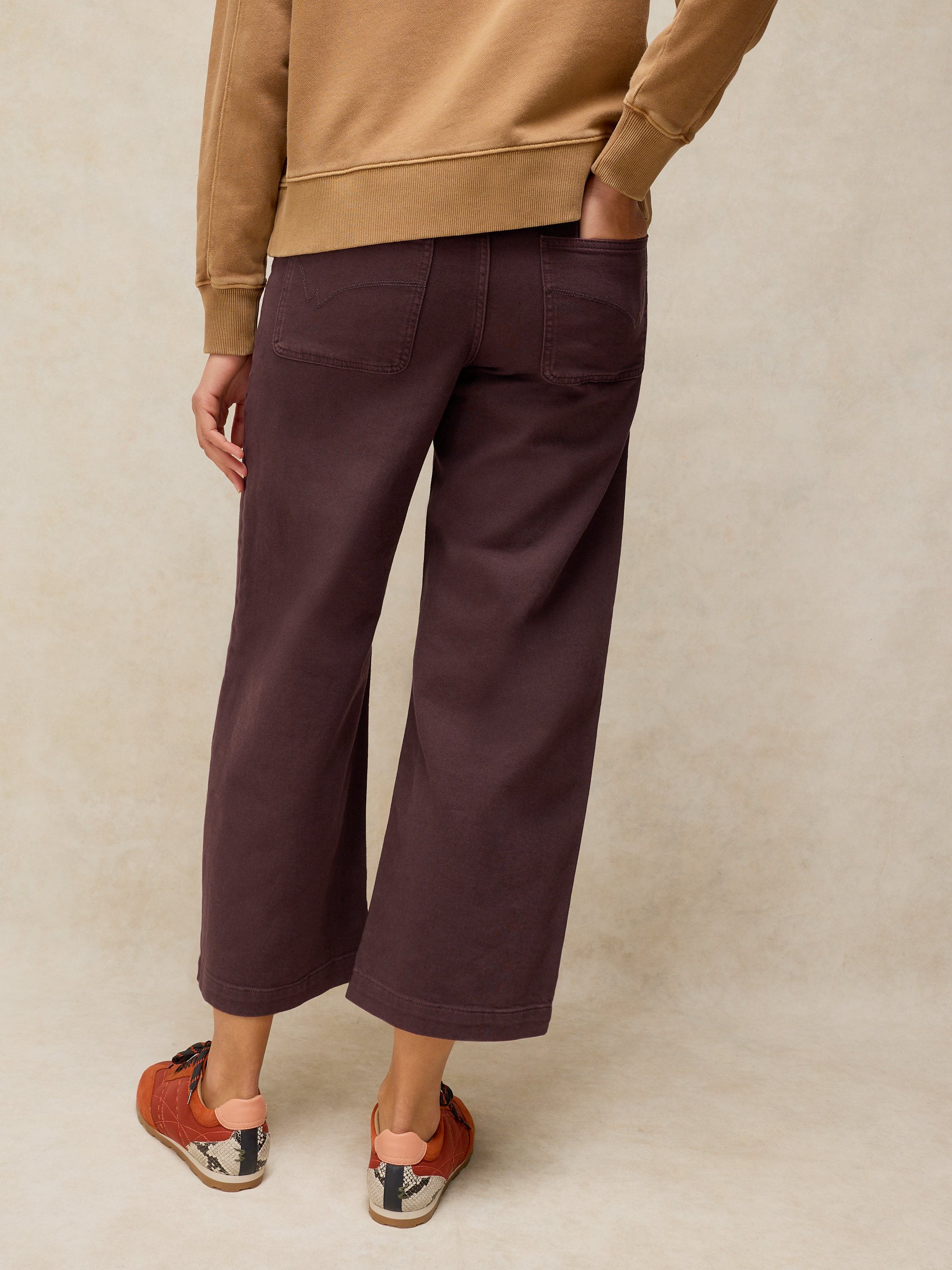 Person wearing brown pants and a beige sweater on a beige background