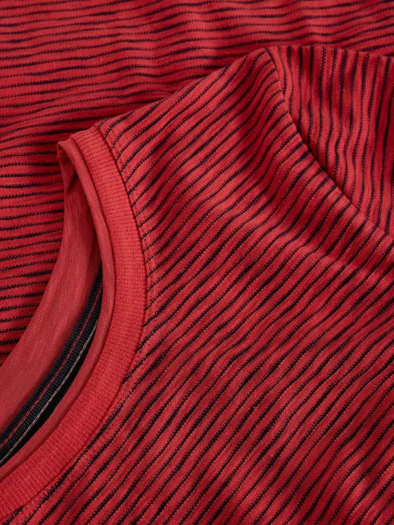 Close-up of a red ribbed knit fabric with thin black vertical stripes and a curved neckline.