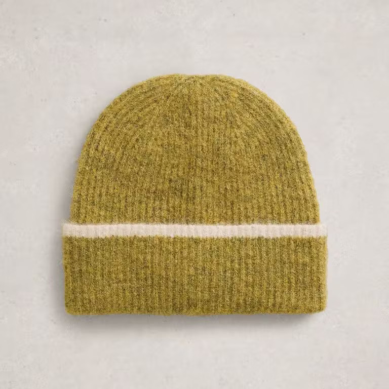 A ribbed knit beanie hat in a muted olive yellow-green color, featuring a single horizontal cream stripe around the middle, laid flat on a light gray textured background.