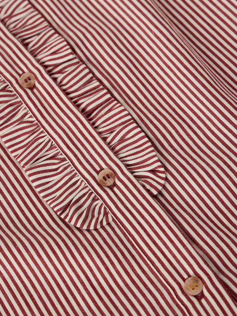 Close-up of a red and white striped blouse with a ruffled collar and decorative buttons.