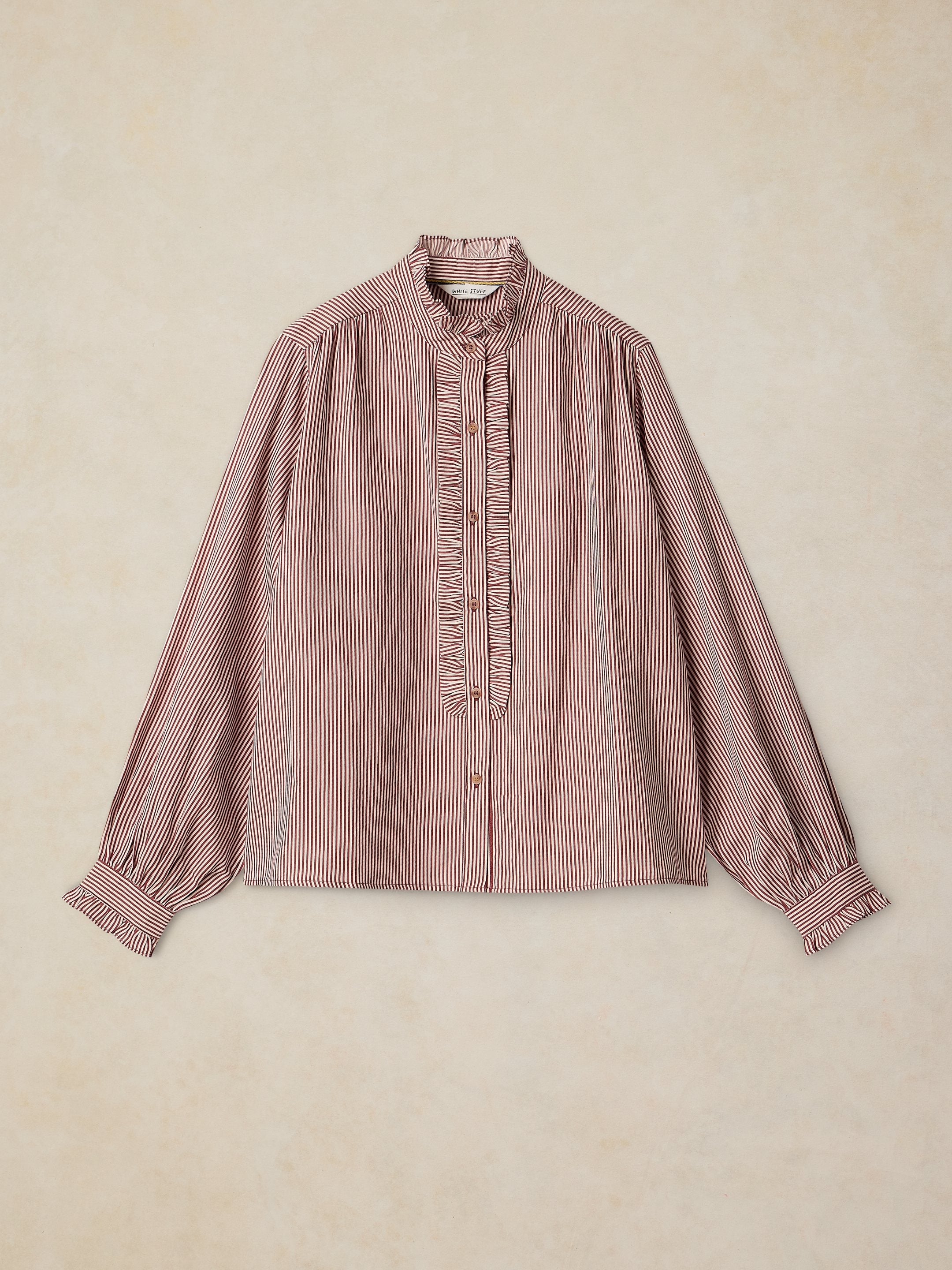 Pink and white striped blouse on a beige background