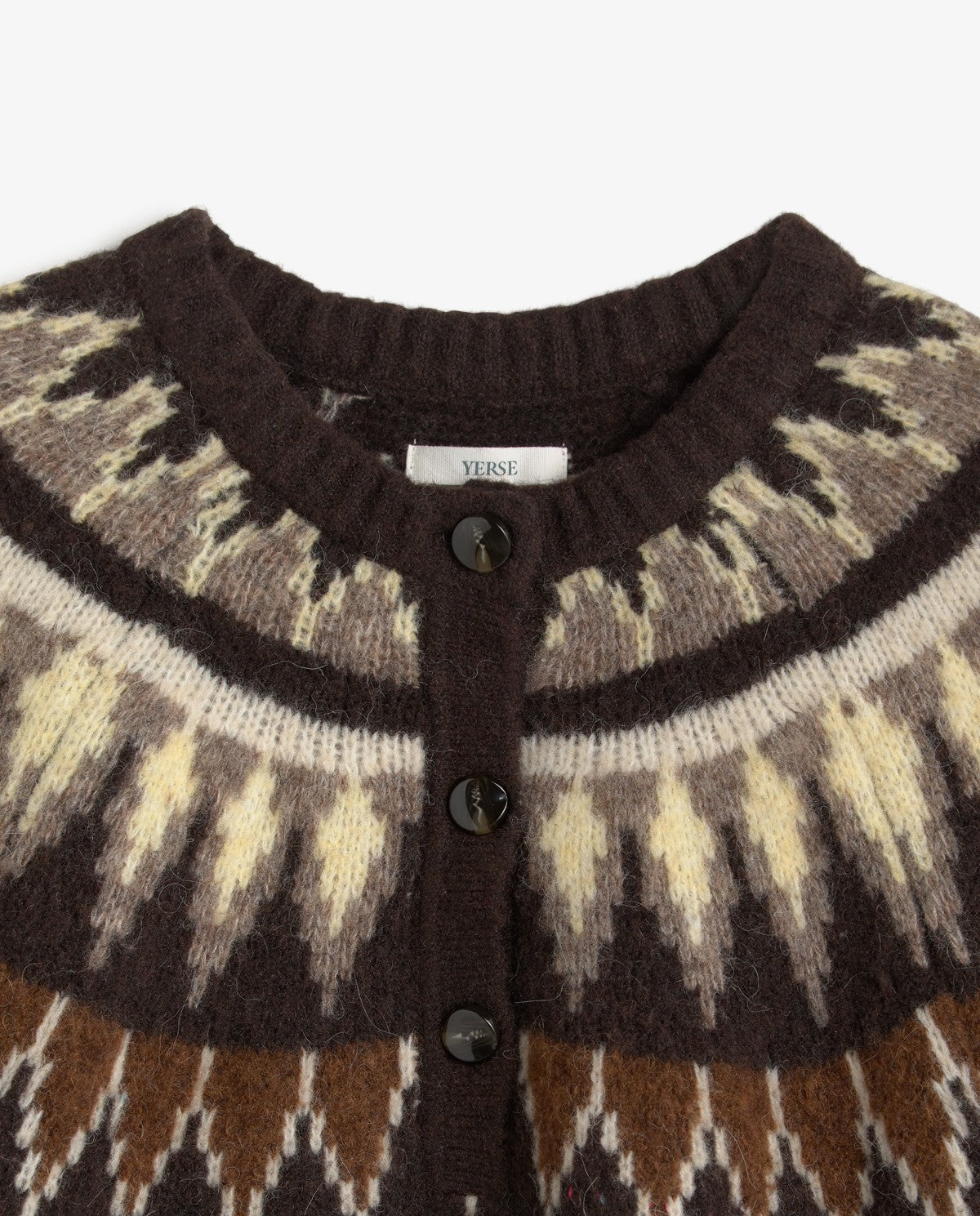 Close-up of a knit cardigan sweater with a dark brown ribbed crew neck, three dark buttons, and a Fair Isle pattern in brown, cream, and beige.