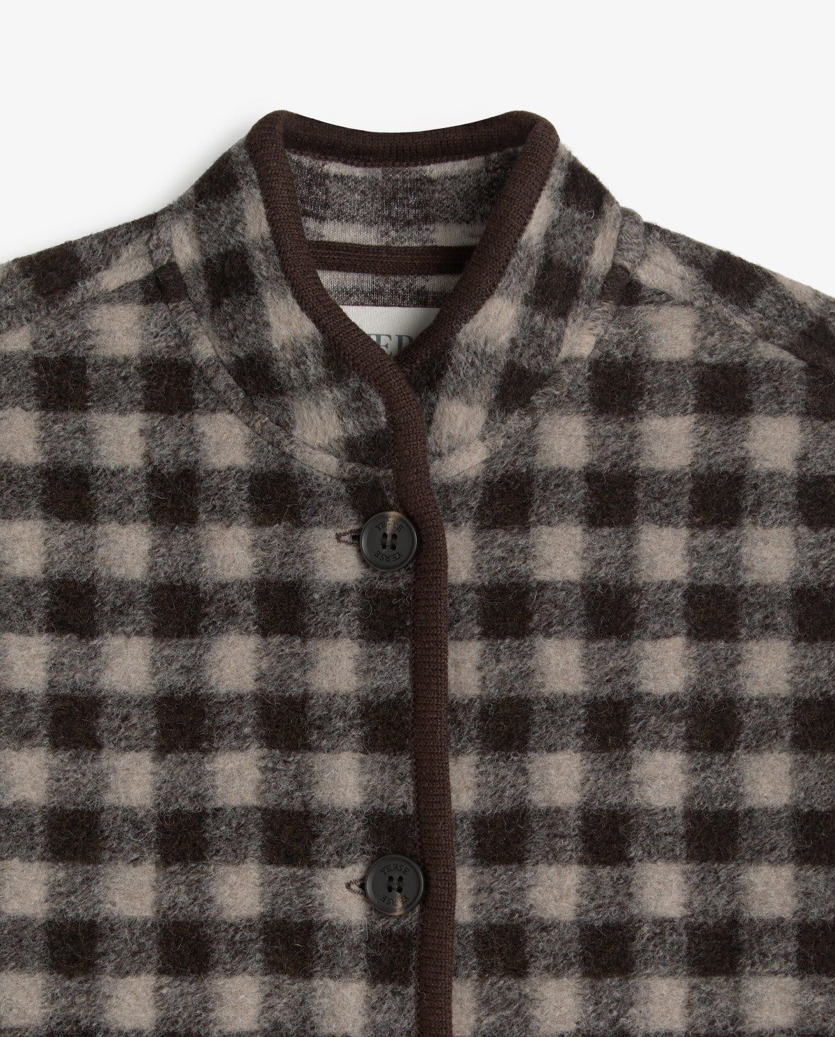 Close-up of a checkered wool-blend cardigan with a dark brown ribbed mock neck, trim, and buttons over a beige and dark brown gingham pattern.