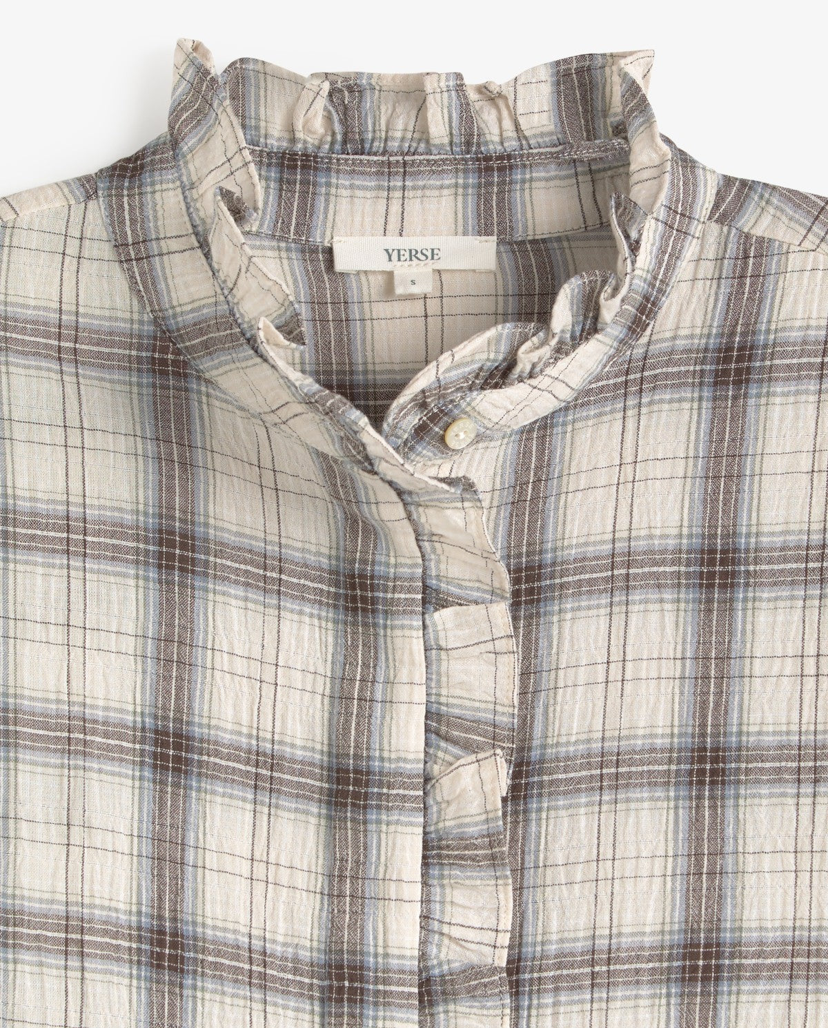 Close-up of a plaid button-up shirt with a ruffled collar, featuring a cream base with brown and light blue plaid lines. The brand name 'VERSE' is visible on the inner neck label.