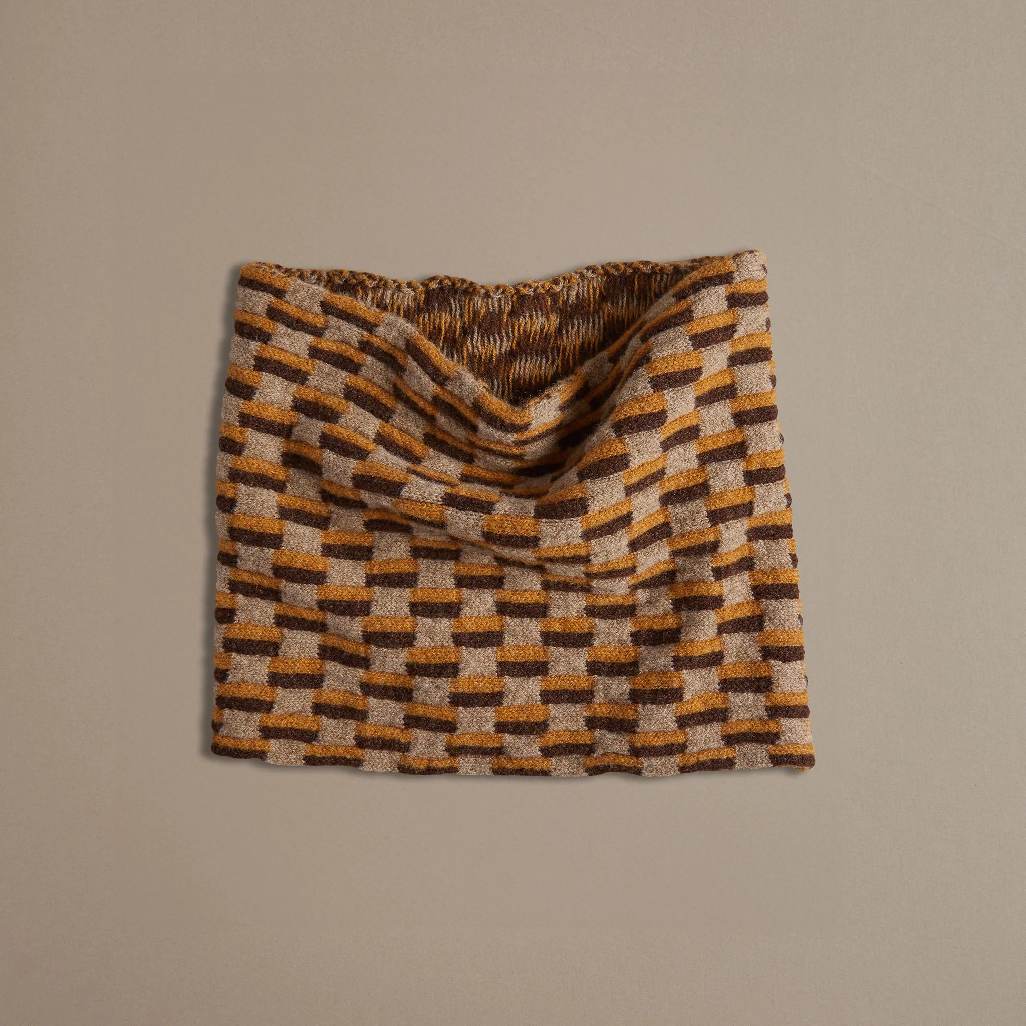 Brown and gold checkered knit neck warmer.  The textured fabric is folded and displayed against a neutral background.
