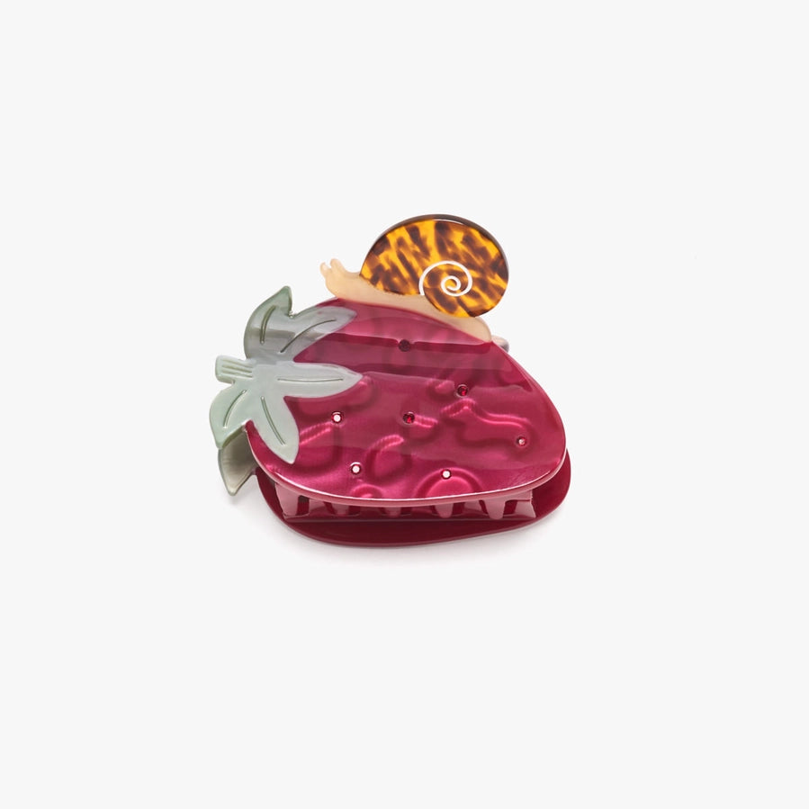 Pink strawberry-shaped hair clip with a snail shaped clasp sits on a white background